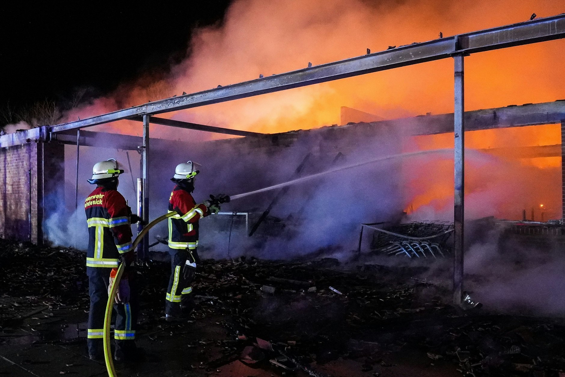 Feuerwehrleute bekämpfen den Großbrand an der Falkenthaler Chaussee in Zehdenick. Das Gebäude mit zwei Supermärkten steht in Vollbrand.