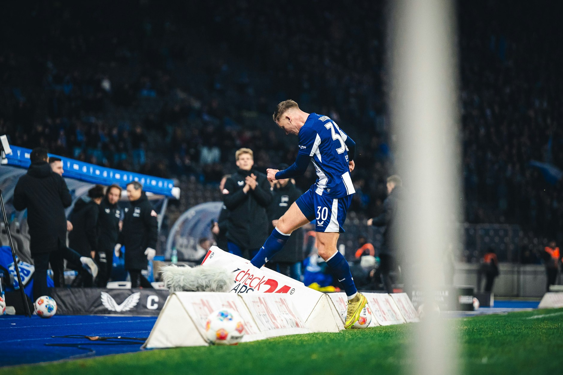 Paul Seguin tritt nach seinem ersten Tor für Hertha BSC im Jubel gegen eine Werbebande.