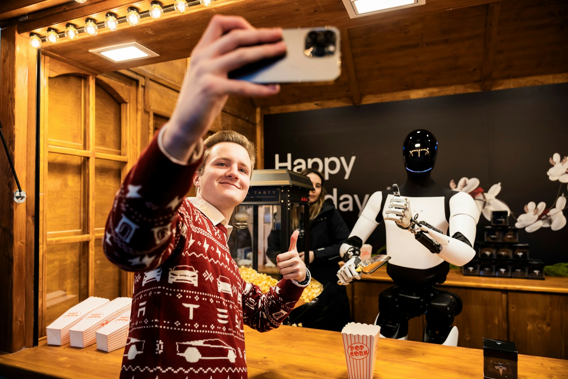 Beliebtes Fotomodell: Ein Besucher fotografiert ein Selfie mit dem Roboter „Optimus“ von Tesla.