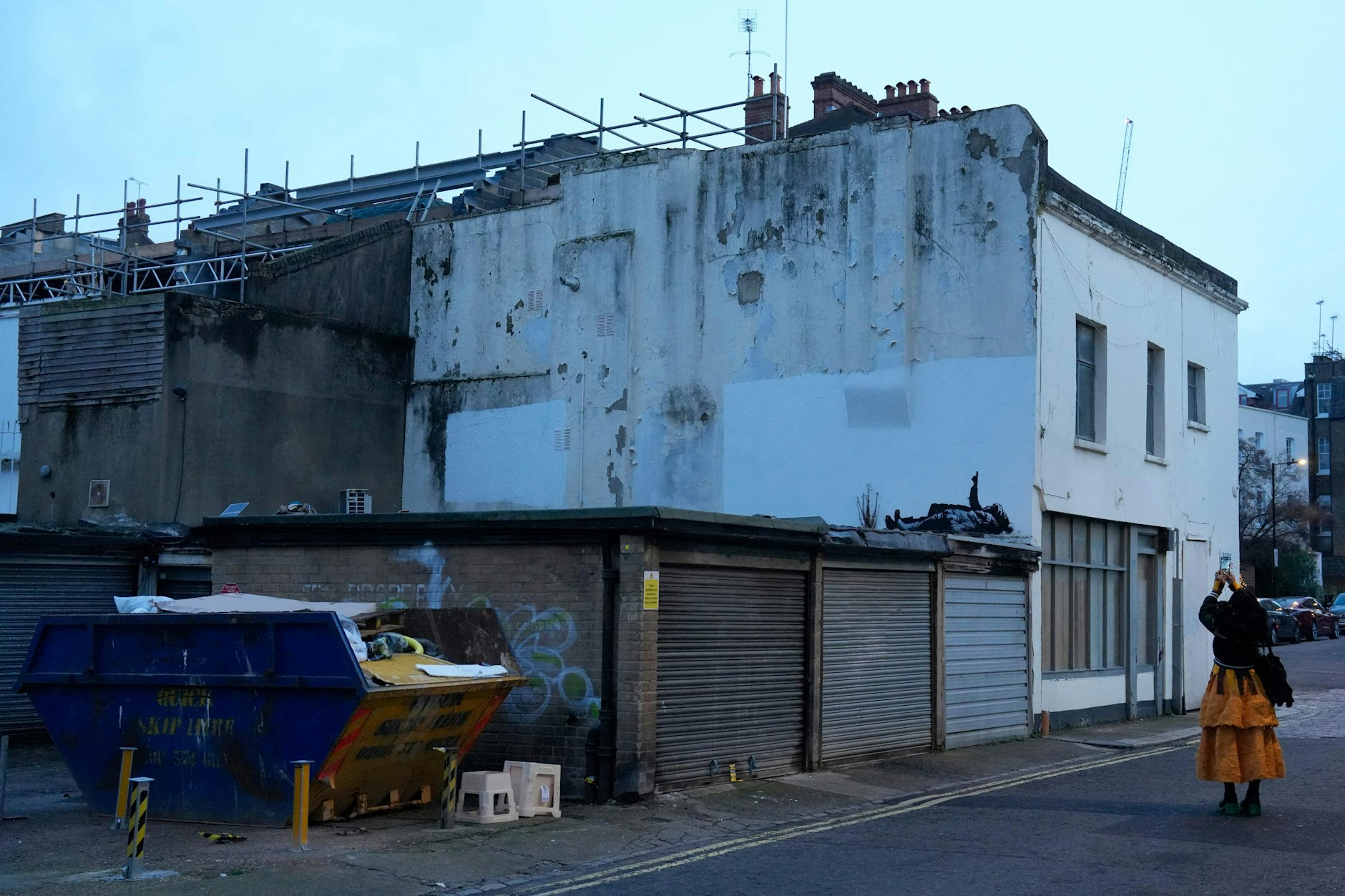 Menschen fotografieren ein Graffiti-Streetart-Werk des Straßenkünstlers Banksy in Bayswater im Westen Londons.