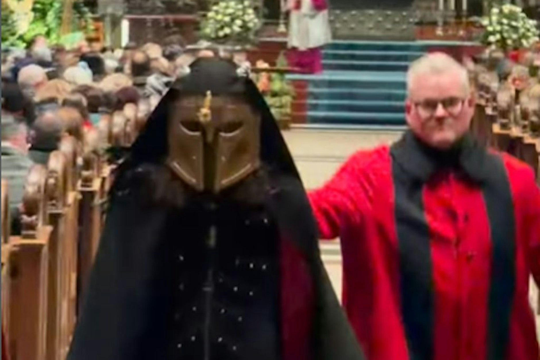 Der Maskenmann wird aus dem Kölner Dom geleitet.