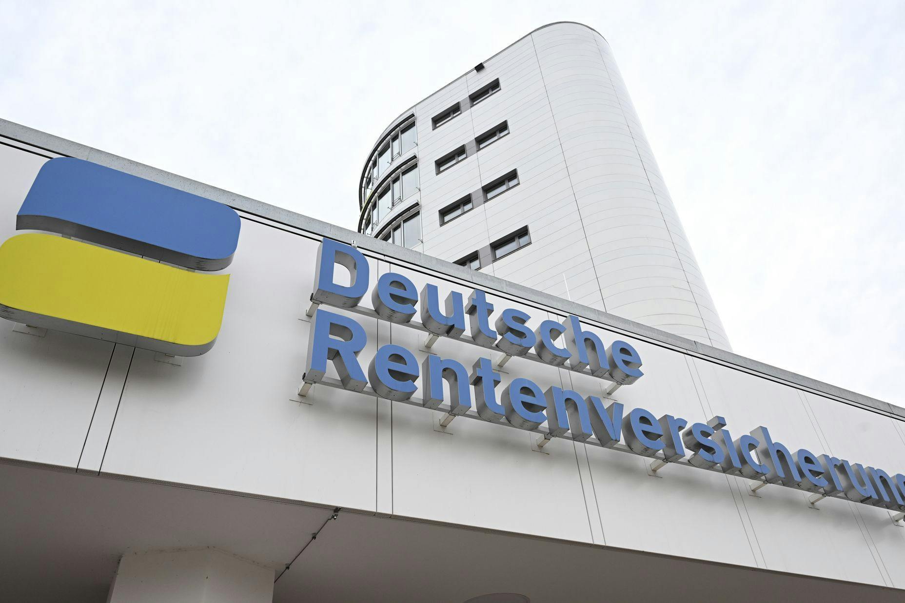 Das Logo der Deutschen Rentenversicherung ist am Eingang eines Gebäudes der Rentenversicherung angebracht.