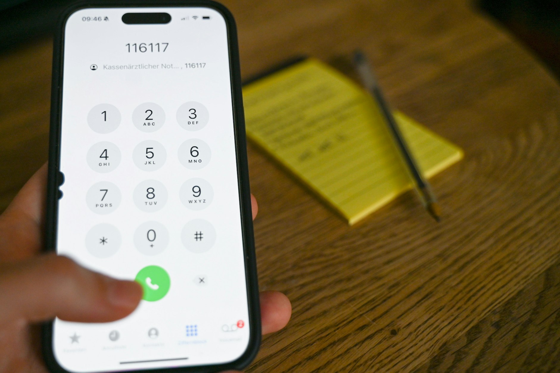 Eine Frau wählt auf einem Handy die Nummer das Kassenärztlichen Notdienstes (Tel. 116 117).
