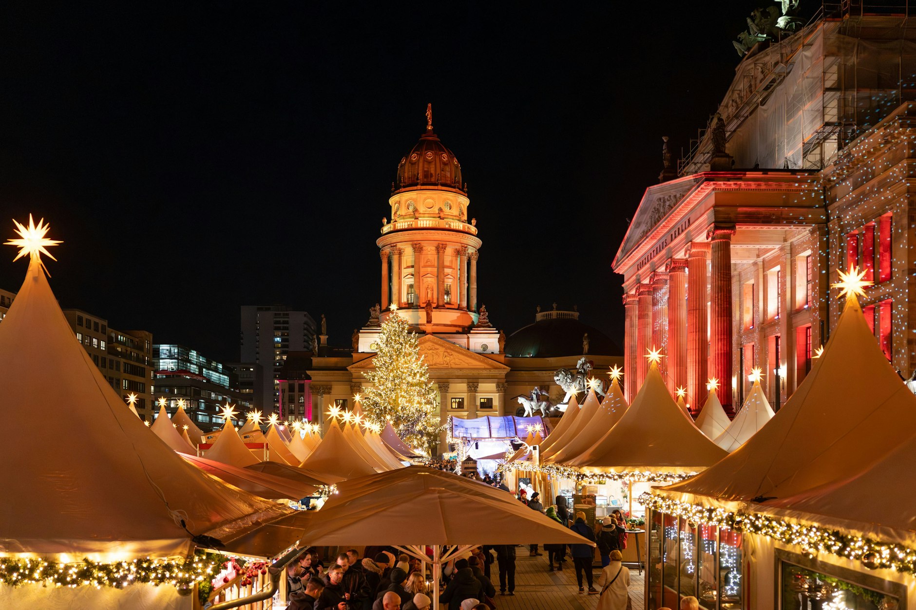 Der Weihnachtszauber geht direkt in die Silvesterparty über: Der Weihnachtsmarkt auf dem Gendarmenmarkt vor der Kulisse von Konzerthaus (re.) und Deutschem Dom läuft bis zum 31. Dezember.
