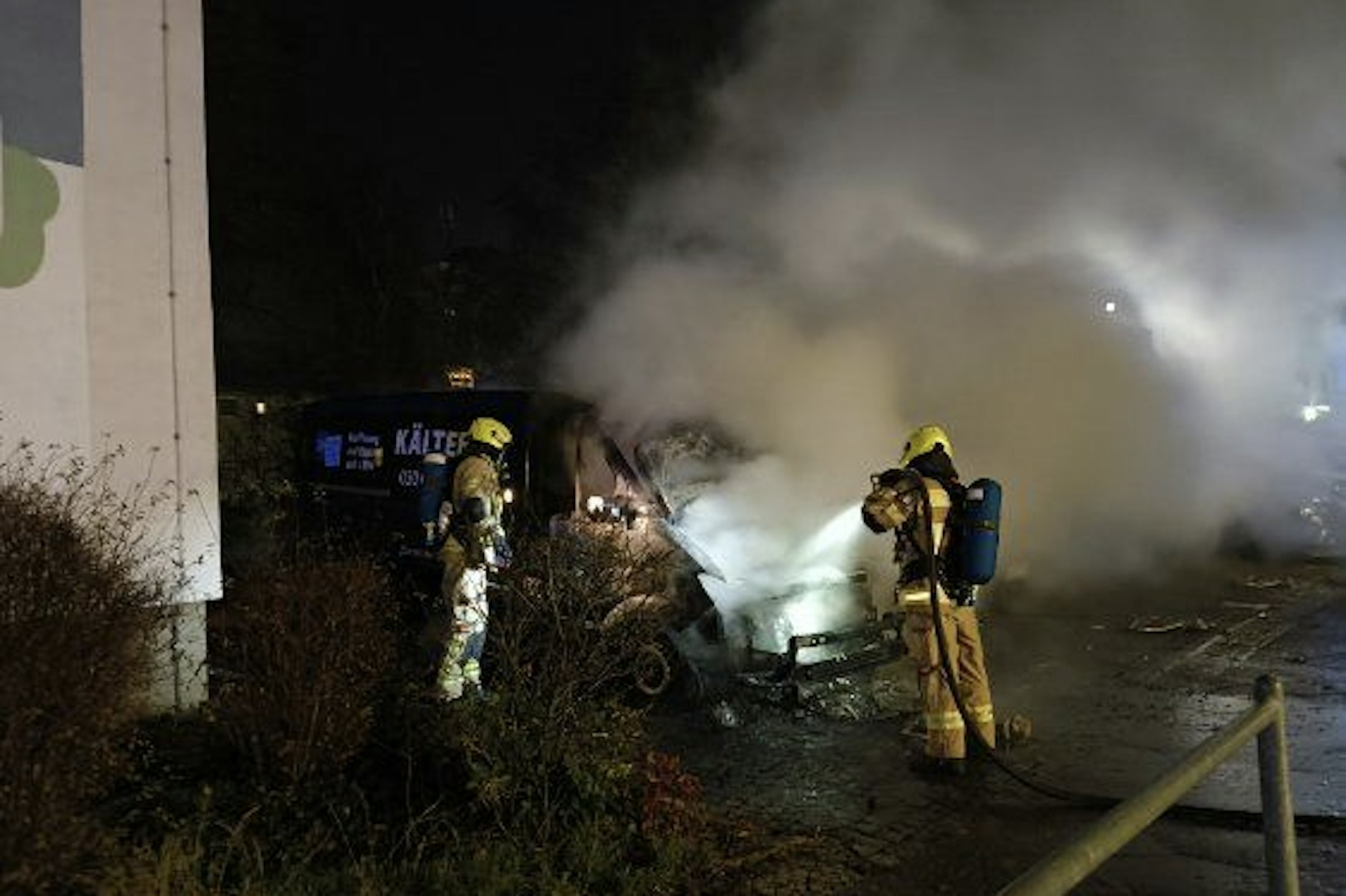 Feuerwehrleute im Einsatz am ausgebrannten Kältebus in Berlin-Moabit.