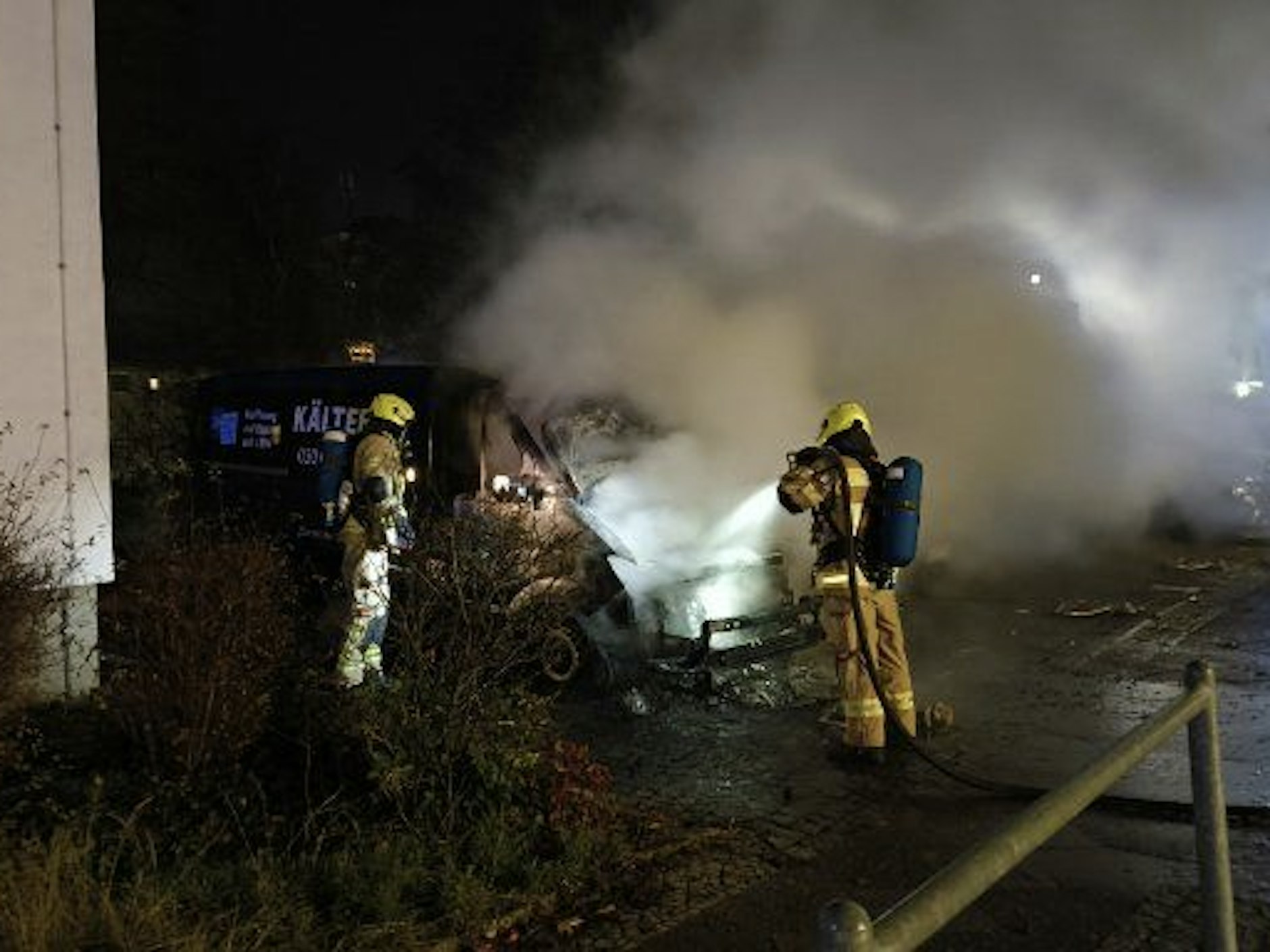 Feuerwehrleute im Einsatz am ausgebrannten Kältebus in Berlin-Moabit