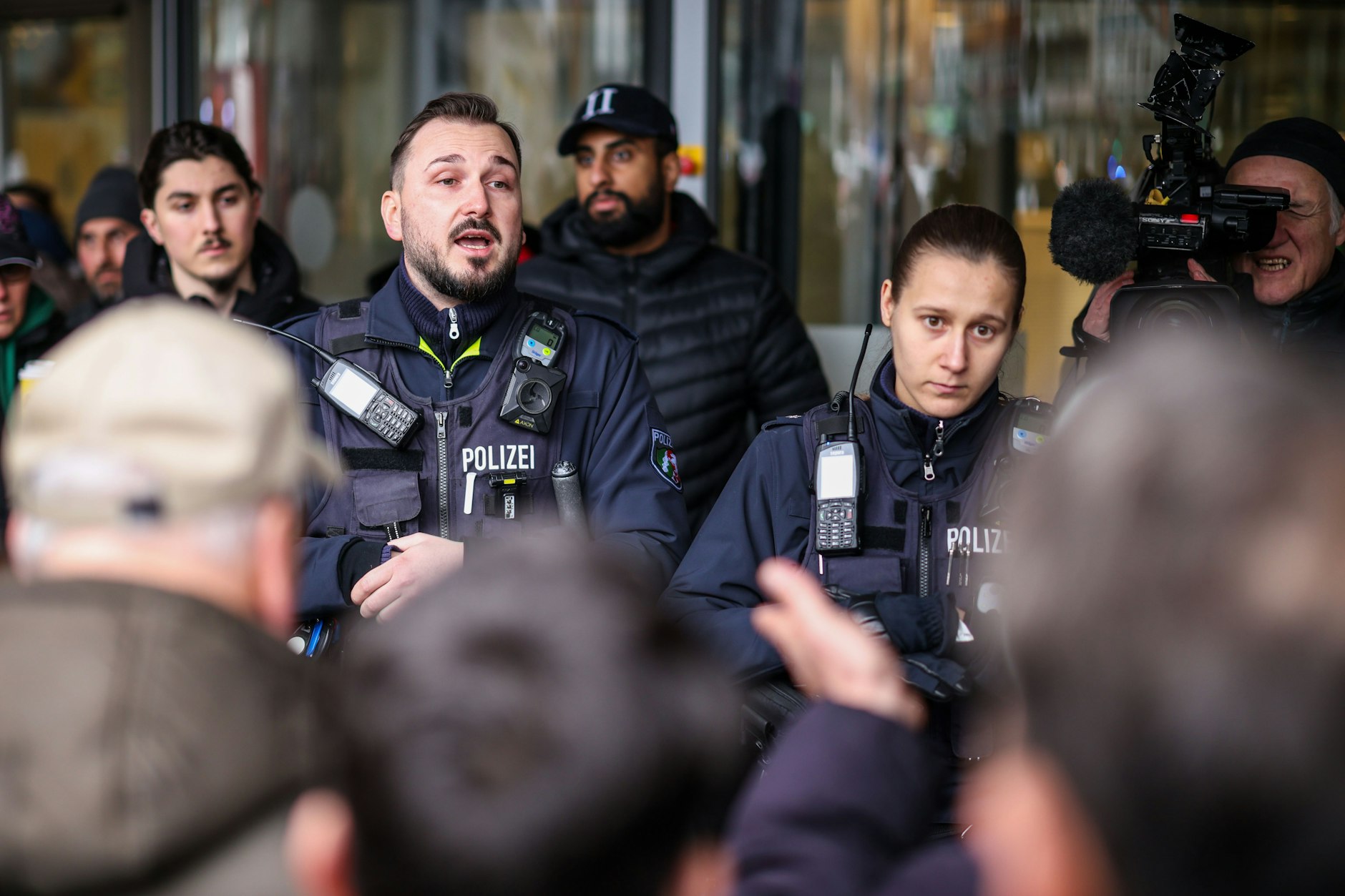 Rund 200 Personen kommt zur Sparkassen-Filiale, um sich einen Eindruck vom Schaden zu verschaffen. Die Polizei muss die aufgebrachte Menge beruhigen.