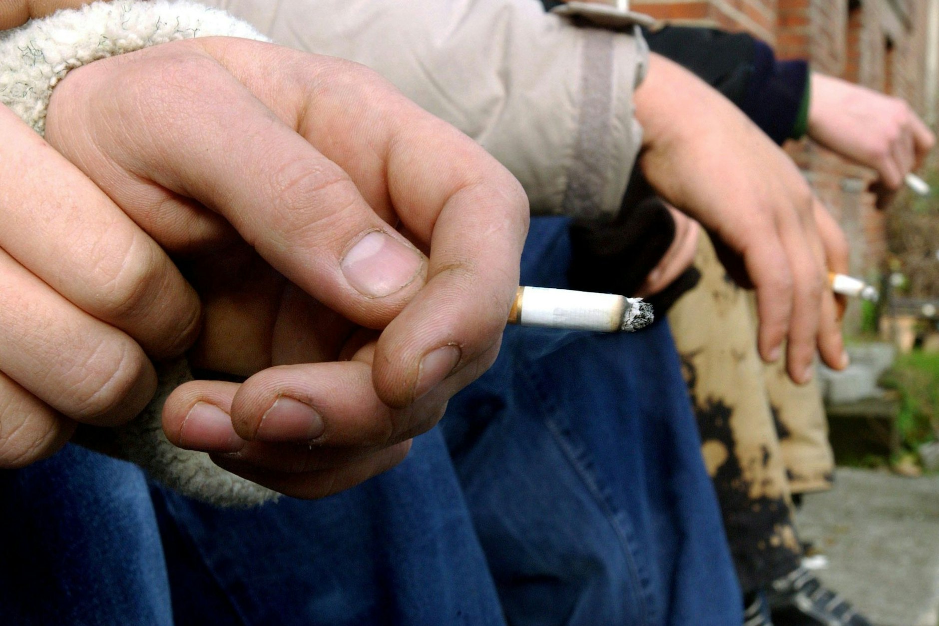 Minderjährige Schüler rauchen auf dem Pausenhof einer Schule Zigaretten.