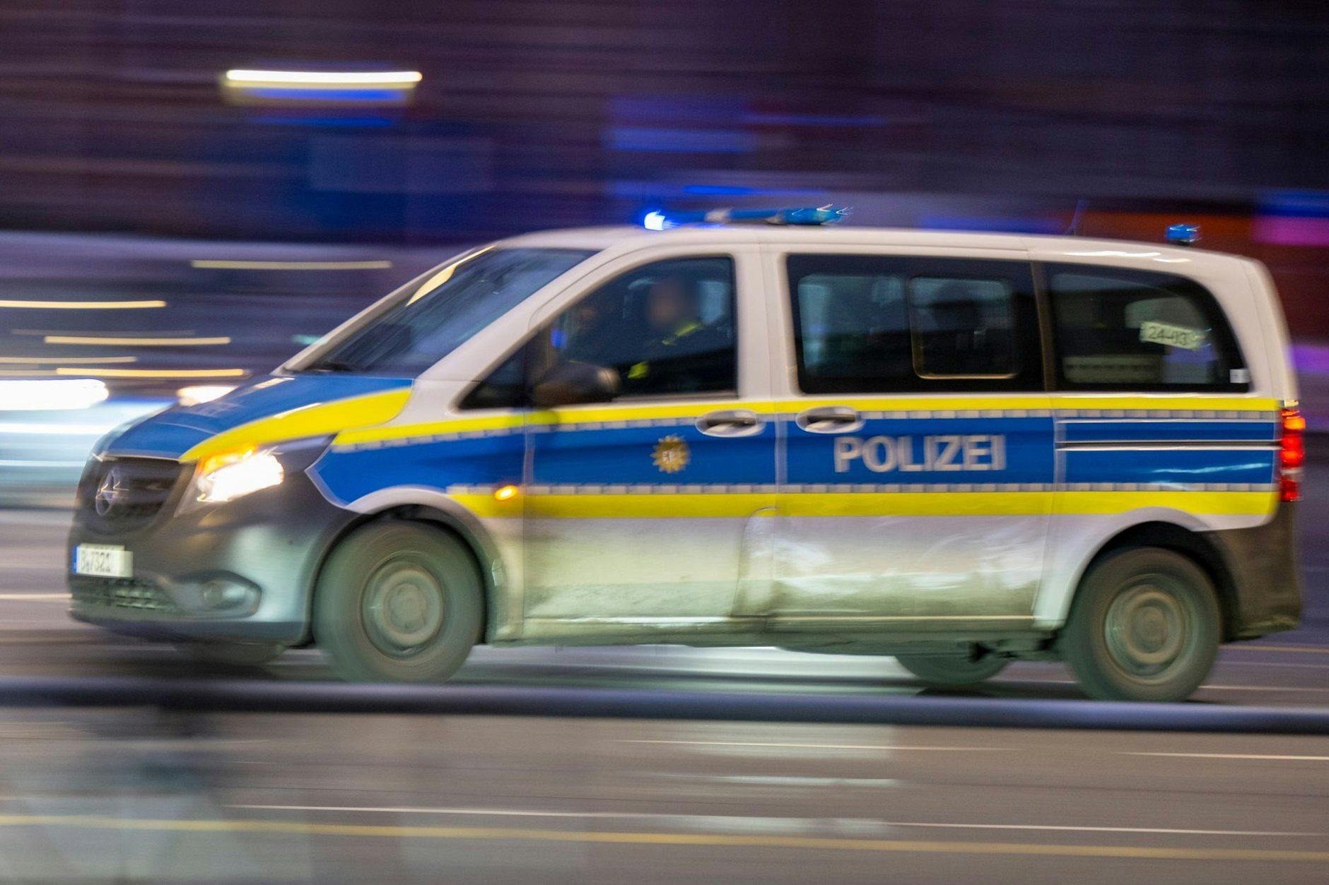 Ein Polizeiauto fährt mit Blaulicht zu einem Einsatz. Waffen werden in Berlin selten eingesetzt.