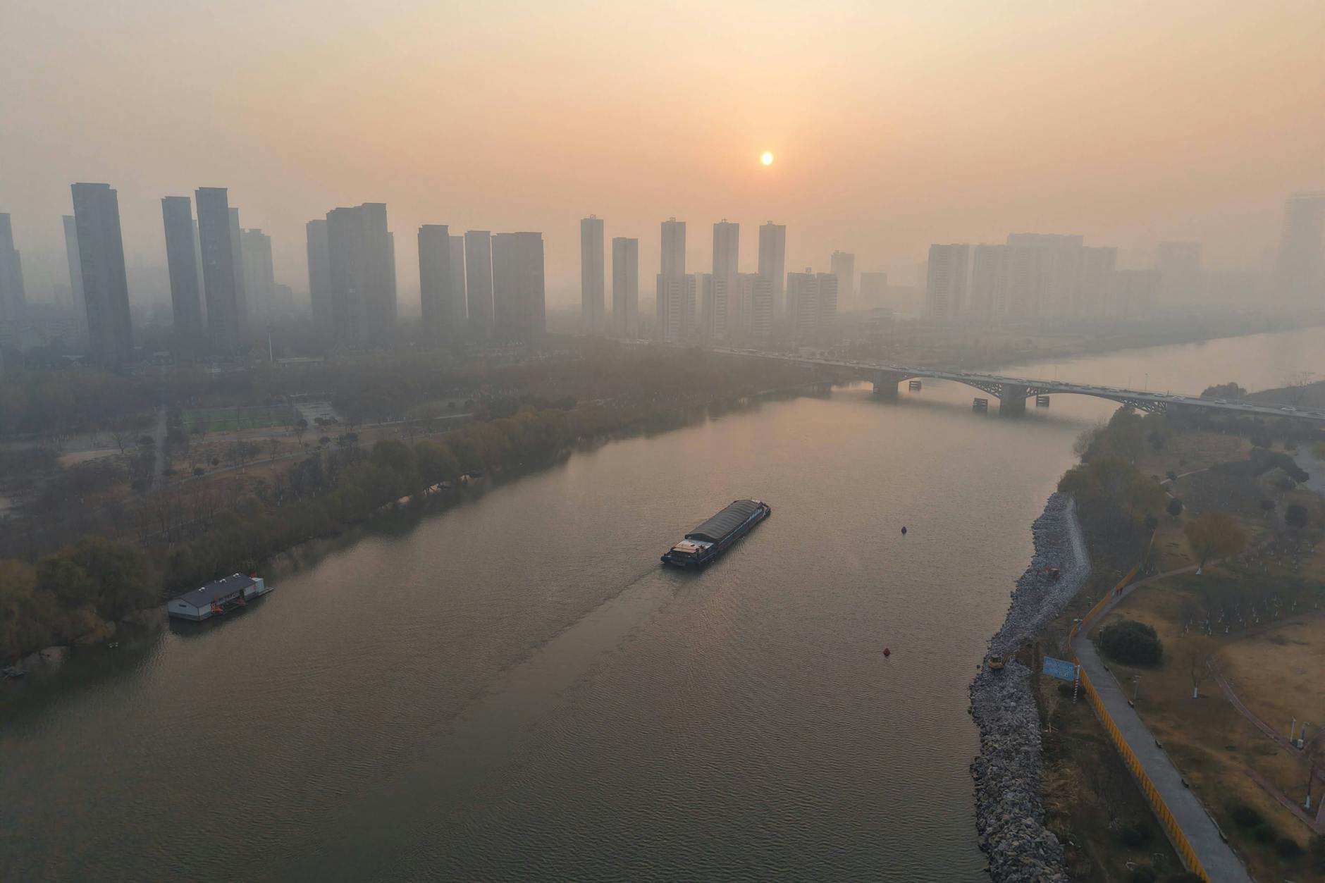 Smogverhangene Hochhäuser im Morgennebel von Fuyang, China.