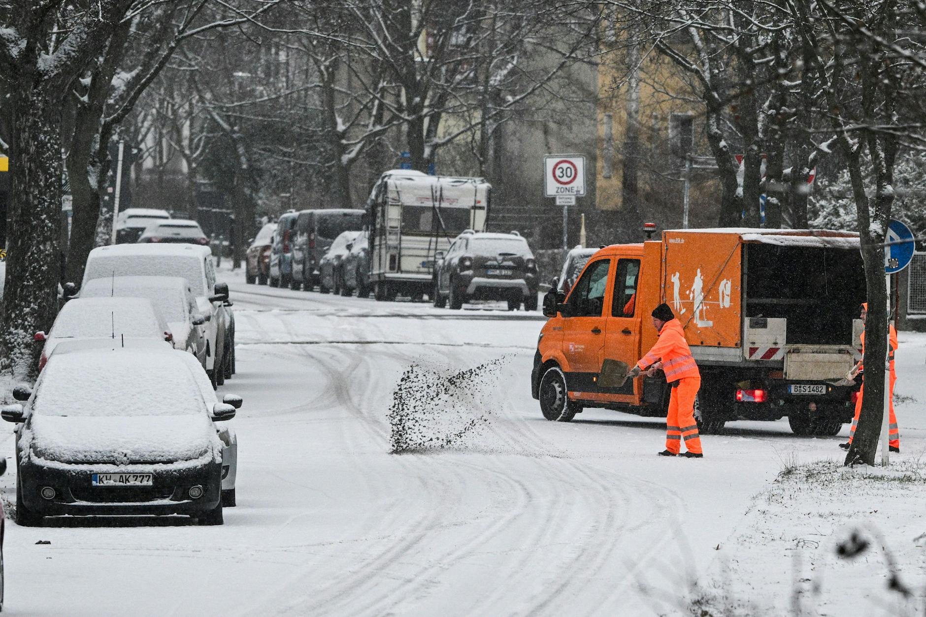 Die Berliner Stadtreinigung streut in den verschneiten Straßen Berlins.