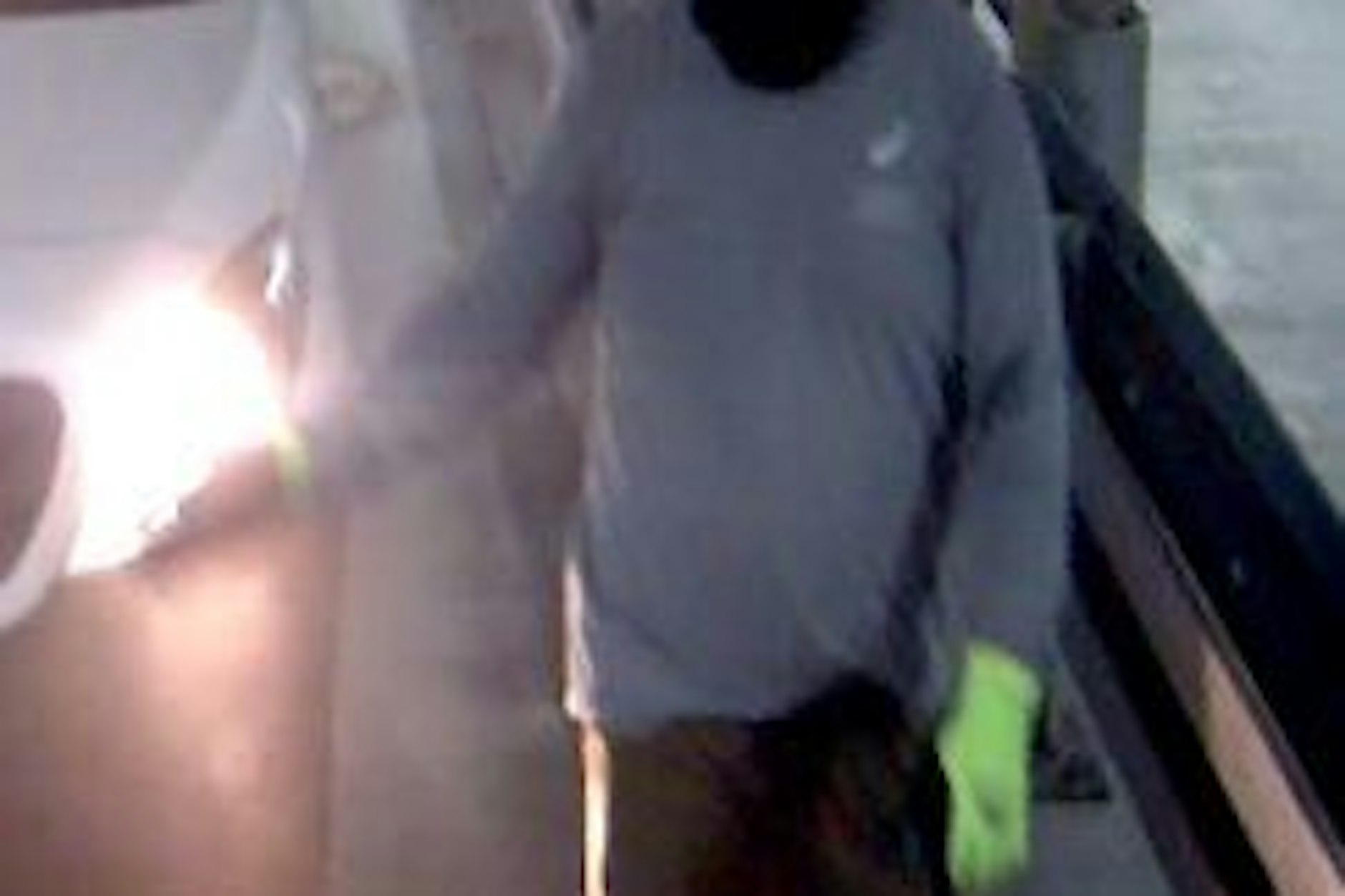 Einer der mutmaßlichen Täter trägt grüne Handschuhe.