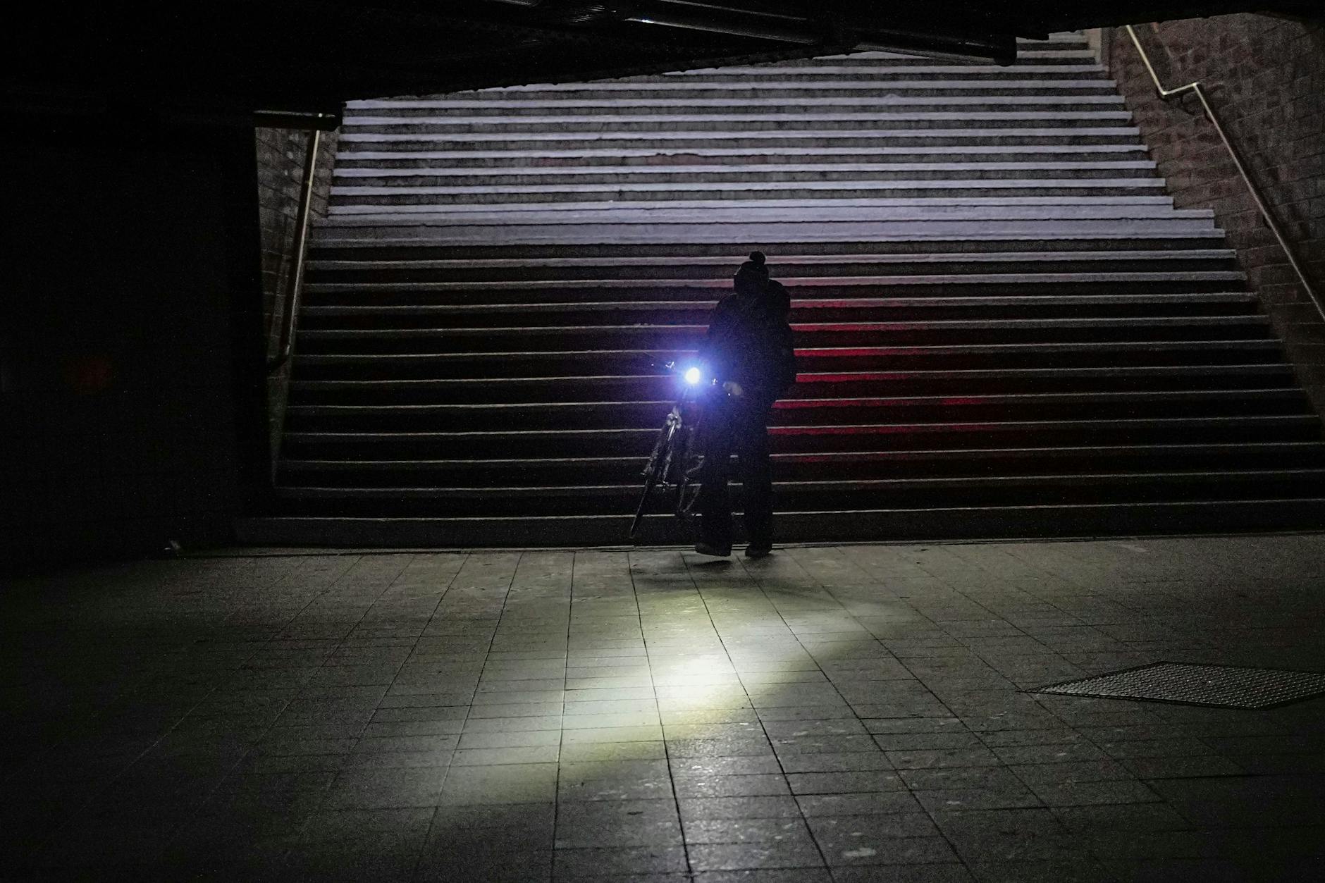 Ein Mann geht mit seinem Fahrrad durch den Bahnhof Wannsee nach einem Stromausfall.