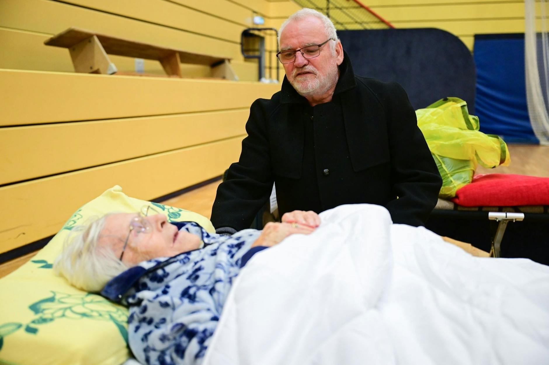 Carsten spricht während des Stromausfalls im Südwesten Berlins in einer Notunterkunft mit seiner Mutter Ingeborg (97), die dort auf einem Feldbett übernachtet hat.