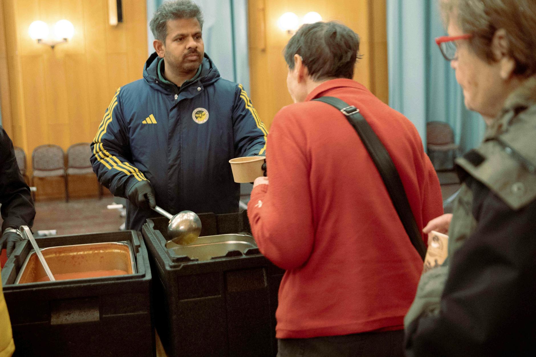 Ehrenamtliche verteilen Essen während des Stromausfalls im Südwesten Berlins in einer Notunterkunft im Bürgersaal im Rathaus Zehlendorf.