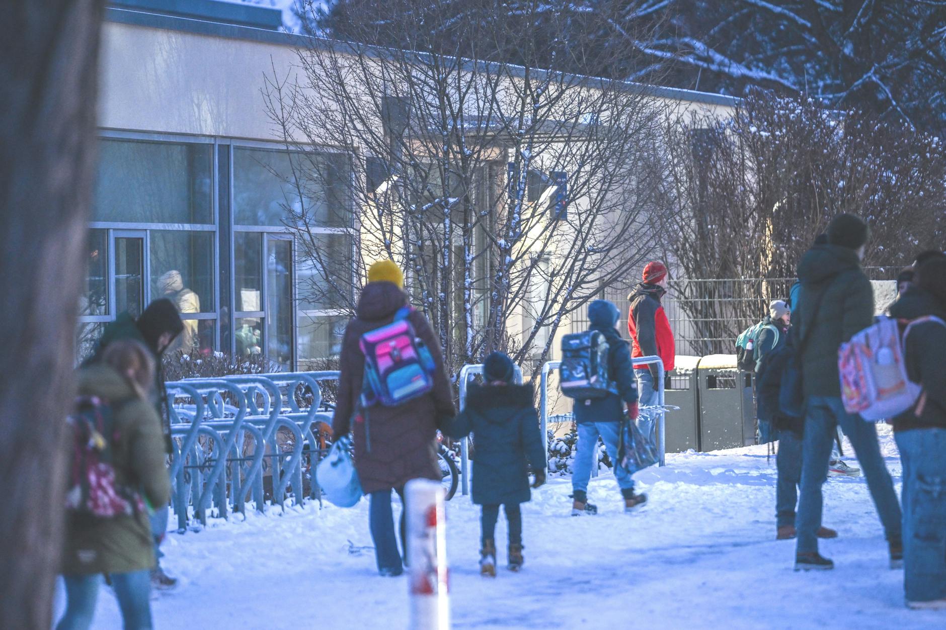 Kinder werden von ihren Eltern zur Mühlenau-Schule gebracht. Wegen eines Stromausfalls hat die Schule zur Notbetreuung geöffnet.