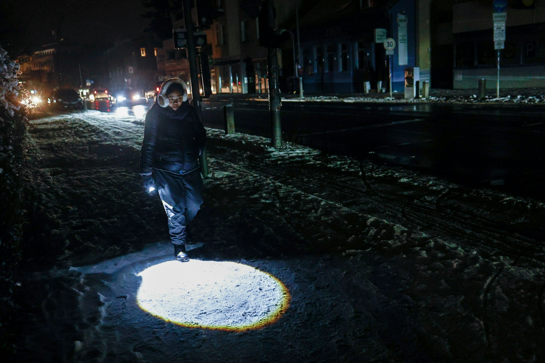 Blackout in Berlin. Eine Person läuft mit einer Taschenlampe durch die Dunkelheit. 