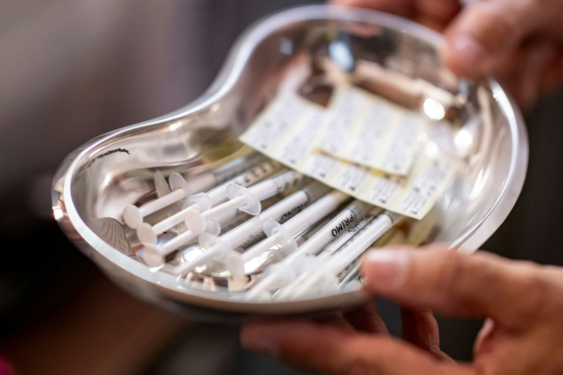 Ein Arzt hält eine Schale mit Corona-Impfstoff in der Hand.