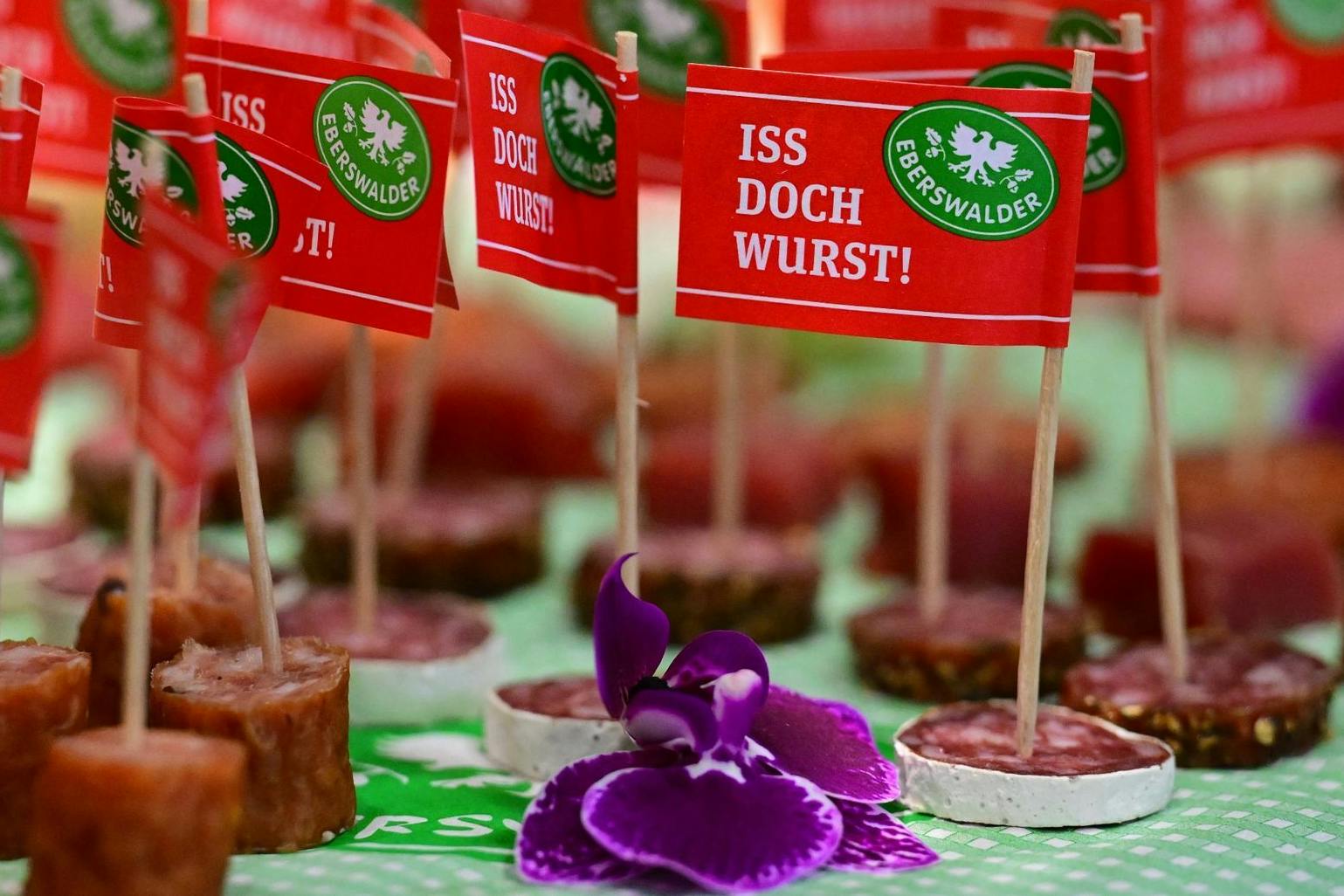Fähnchen mit der Aufschrift „Iss doch Wurst!“ stecken in Salami-Häppchen der Eberswalder Wurst GmbH.