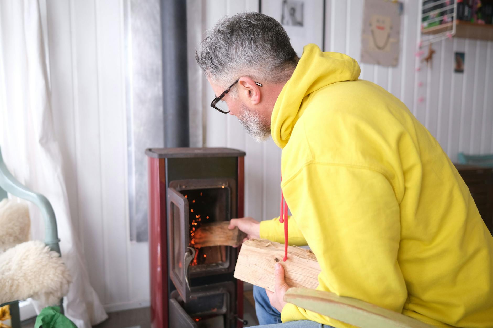 Christian P. Doetsch legt Holz in seinem Ofen nach.