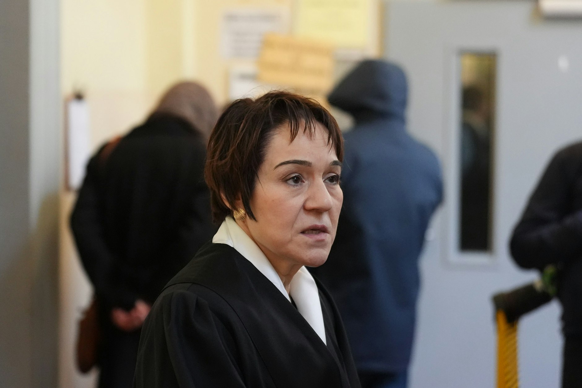 Rechtsanwältin Christiane Yüksel ist die Verteidigerin des Angeklagten, im Hintergrund zwei Angehörige von Shahriar J.