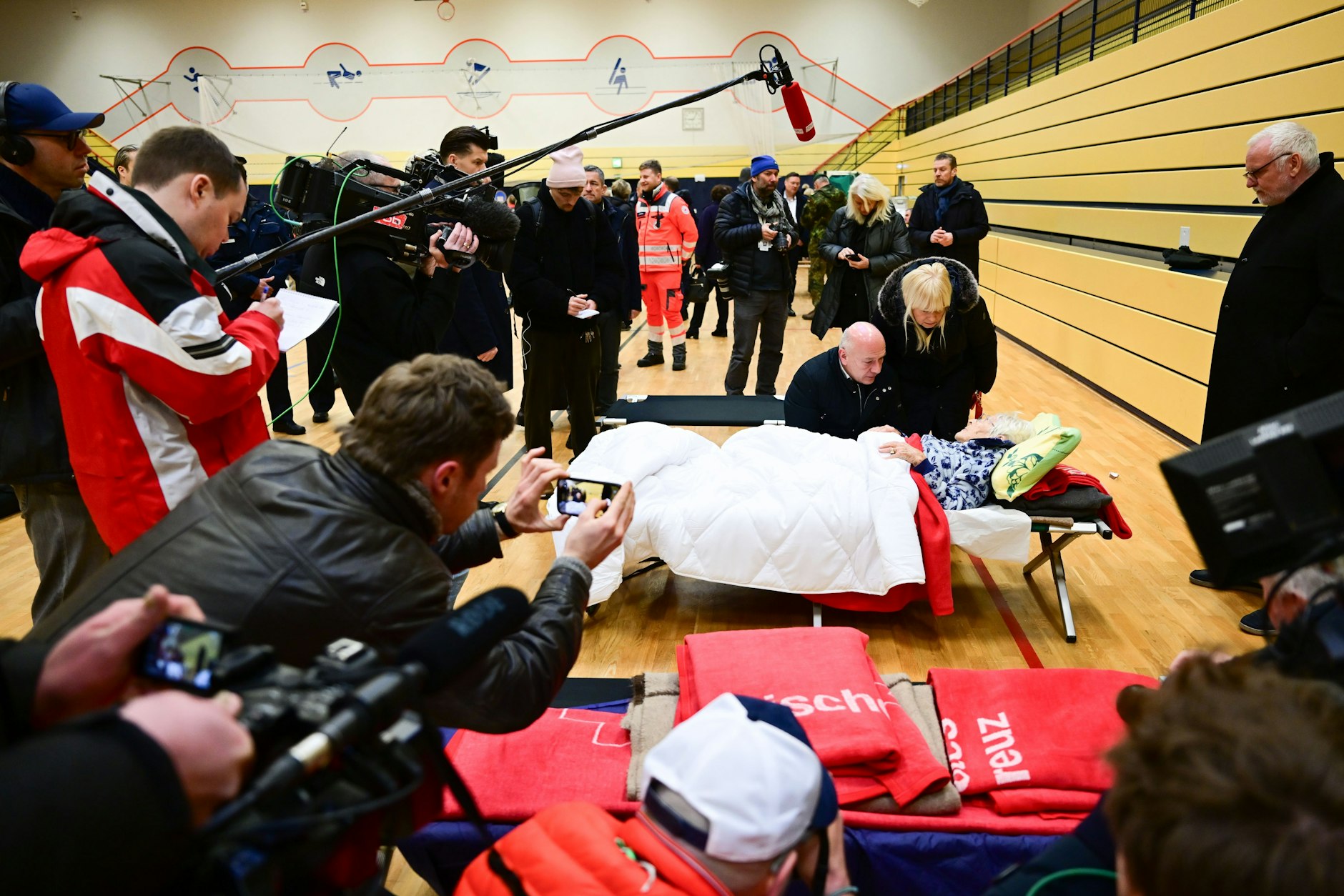 Kai Wegner (CDU), Regierender Bürgermeister von Berlin, und Iris Spranger (SPD), Senatorin für Inneres und Sport, sprechen während des Stromausfalls im Südwesten Berlins in einer Notunterkunft mit einer 97-Jährigen.