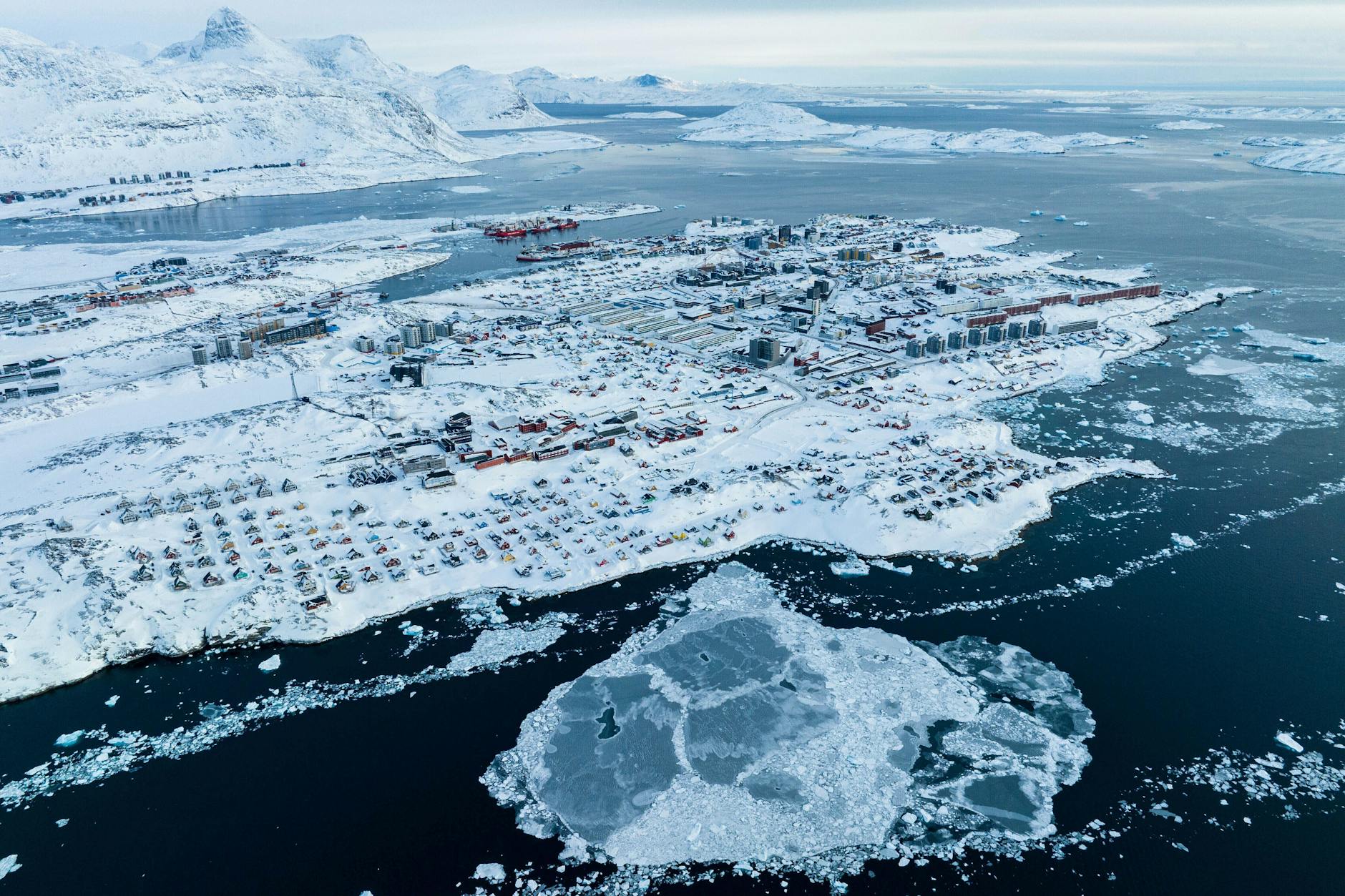 Grönland: Von Schnee bedeckte Häuser sind an der Küste einer Meeresbucht von Nuuk zu sehen.