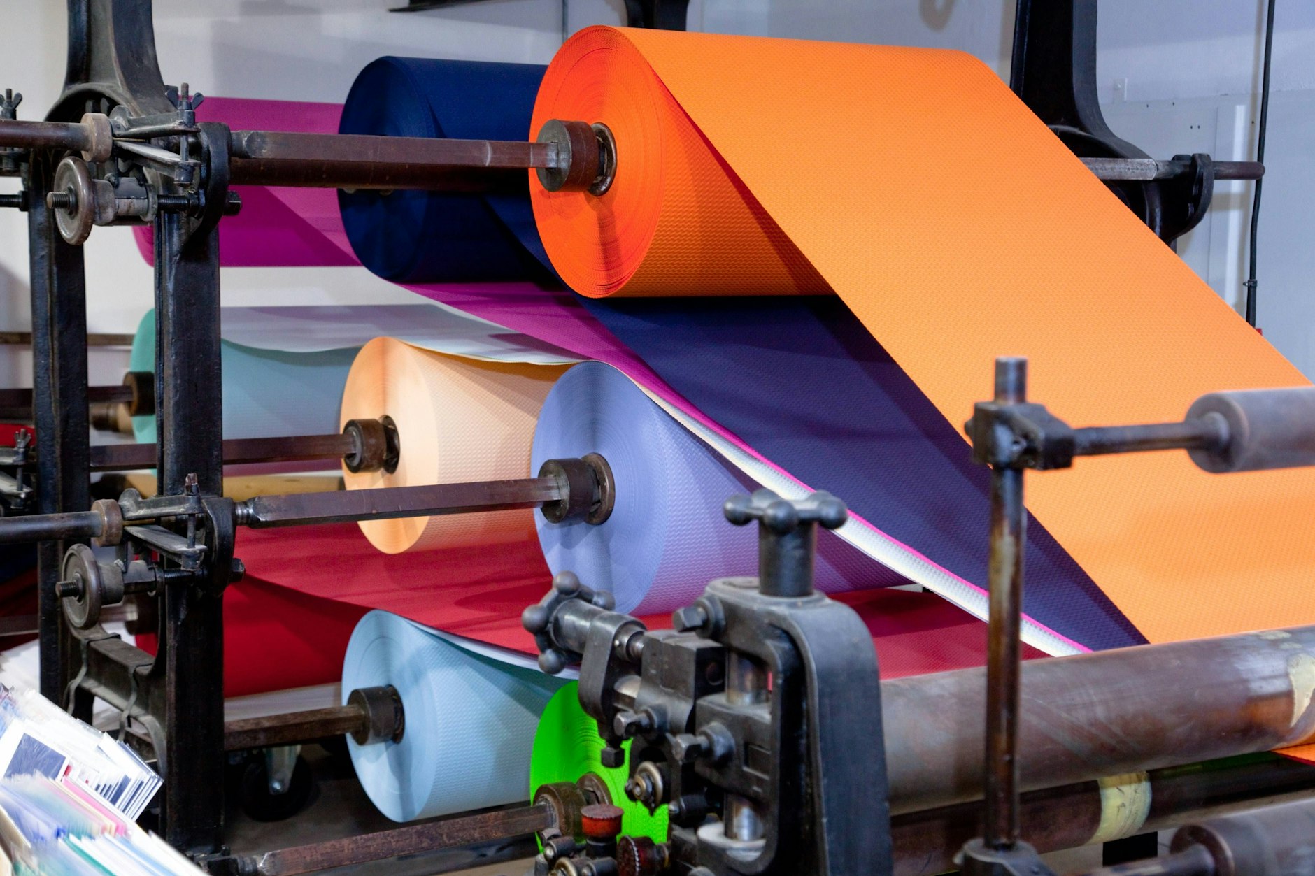 Farbige Papierrollen auf einer Papierschneidemaschine – die Perfecta Schneidemaschinenwerk GmbH Bautzen hat Insolvenz angemeldet.