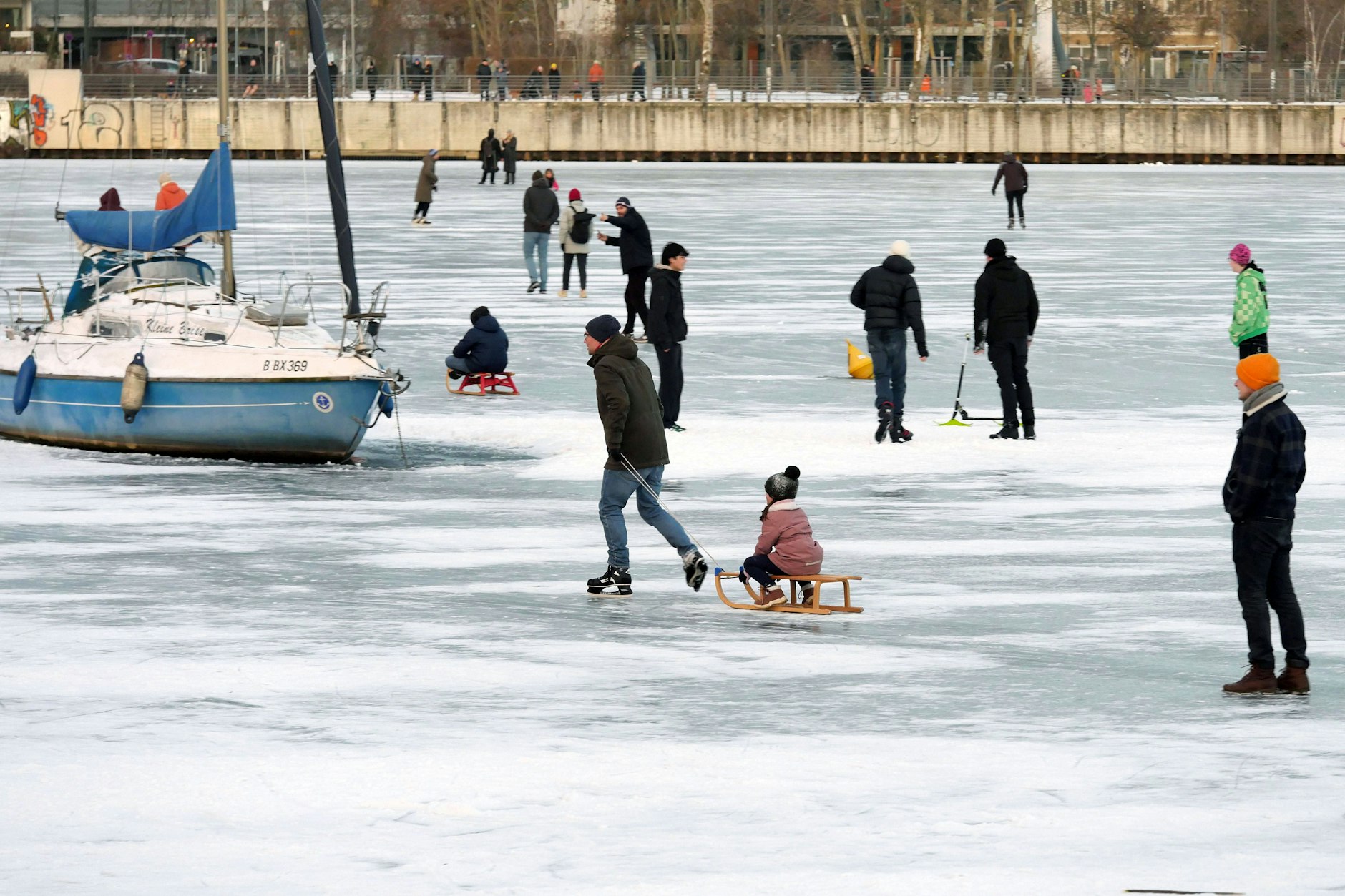 Berliner laufen und schlittern über eine zugefrorene Wasserfläche in der Rummelsburger Bucht.