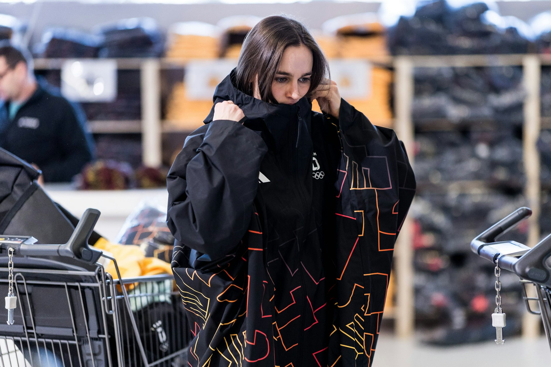 Begeisterung sieht anders aus: Skispringerin Selina Freitag steigt in den Poncho, in dem die Sportler bei der Olympia-Eröffnung antreten sollen.