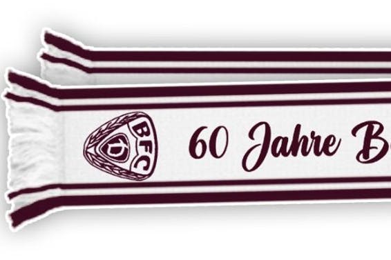 Das ist nur das eine Ende des Schals, nach rechts geht er weiter. Komplett steht drauf: „60 Jahre Berliner Fussballclub Dynamo“.