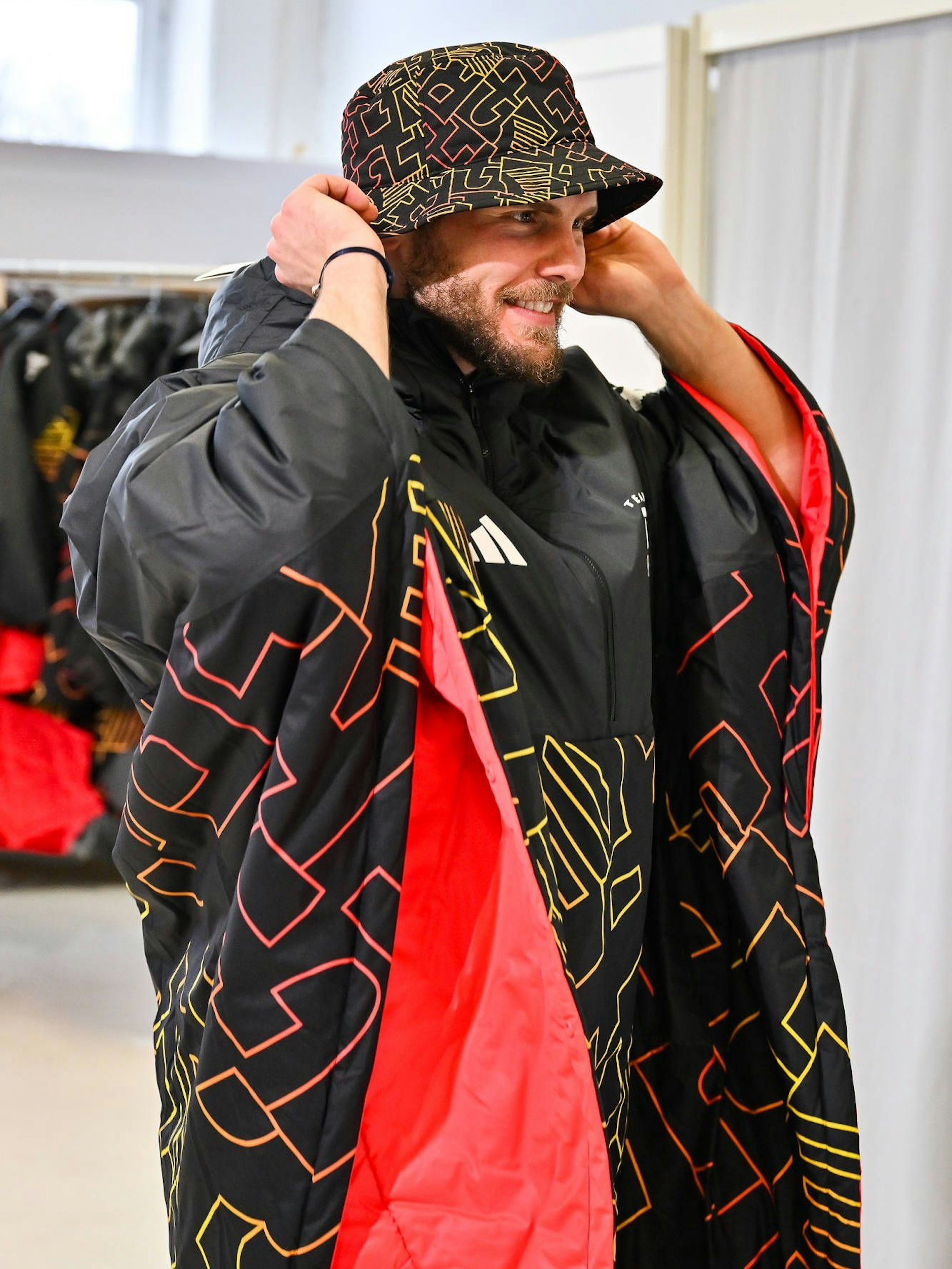 Wenigstens scheint das Outfit warm zu sein: Eishockeyspieler Parker Tuomie probiert Poncho und Anglerhut.