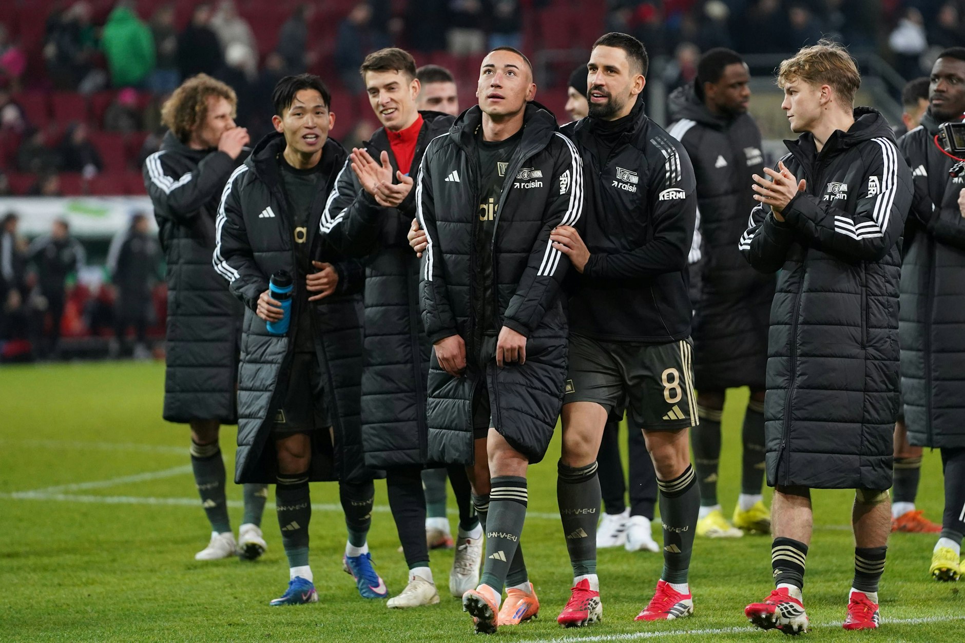 Vizekapitän Rani Khedira schickt den Torschützen Marin Ljubicic zu den mitgereisten Fans in Augsburg.