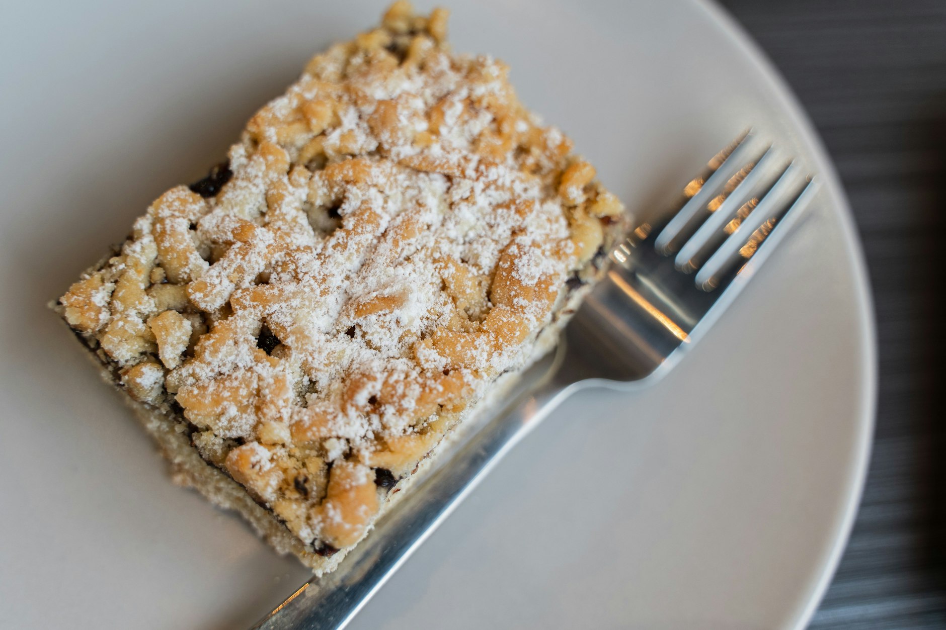 Ein Stück Streuselkuchen mit Puderzucker schmückt und bereichert jede Kaffeetafel. Lassen Sie es sich schmecken!