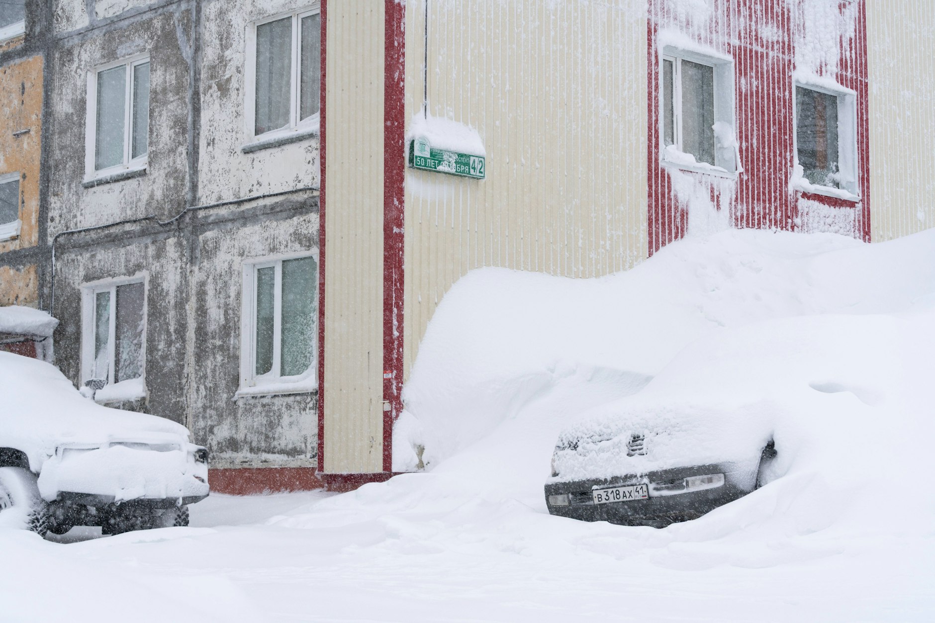 Autos verschwinden vor Wohnhäusern unter den Schneemassen des Jahrhundertwinters auf Kamtschatka.