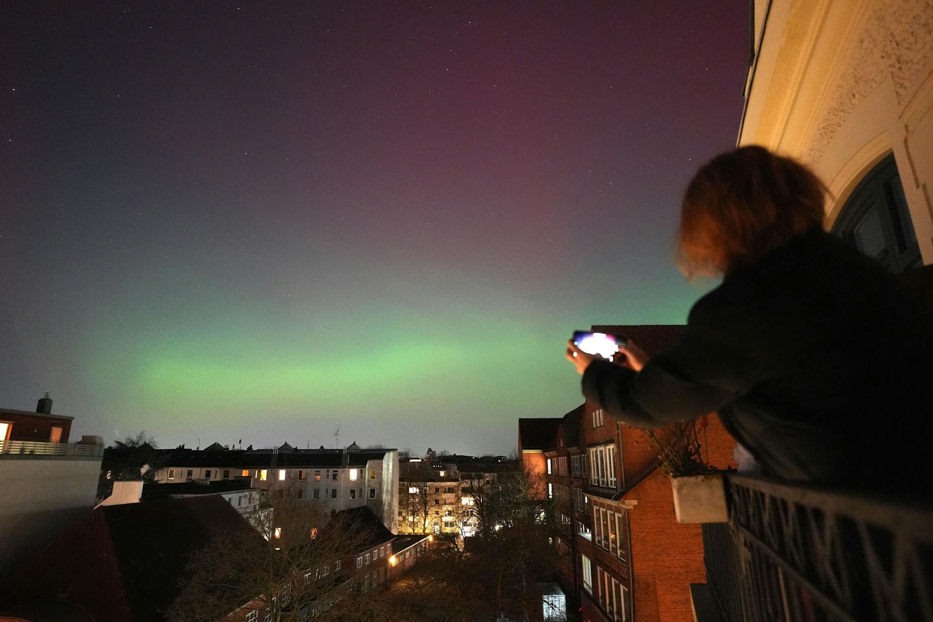 Polarlichter leuchten am Nachthimmel über der Hansestadt Hamburg und laden zum Fotografieren ein.