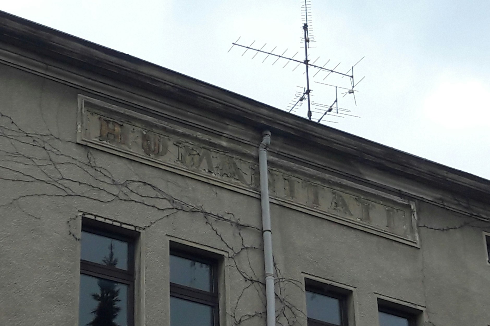 Die Inschrift „Humanitati“ steht auf dem alten „Pop Inn“. <a target="_blank" rel="noopener" href="https://de.wikipedia.org/wiki/Menschlichkeit">Humanität (lateinisch humanitas)</a> bezeichnet eine Haltung der Nächstenliebe und Toleranz.