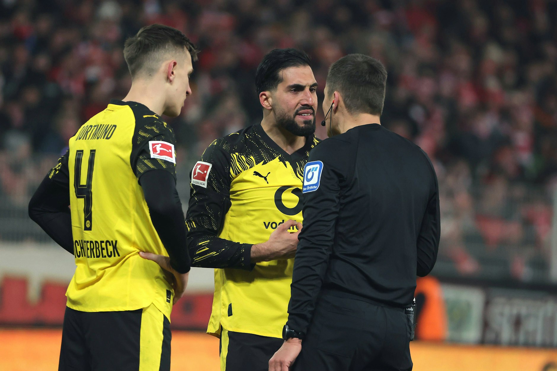 Emre Can diskutiert nach seinem Schubser mit Schiedsrichter Robert Hartmann und kassiert danach von den Union-Fans Pfiffe und Schmährufe.