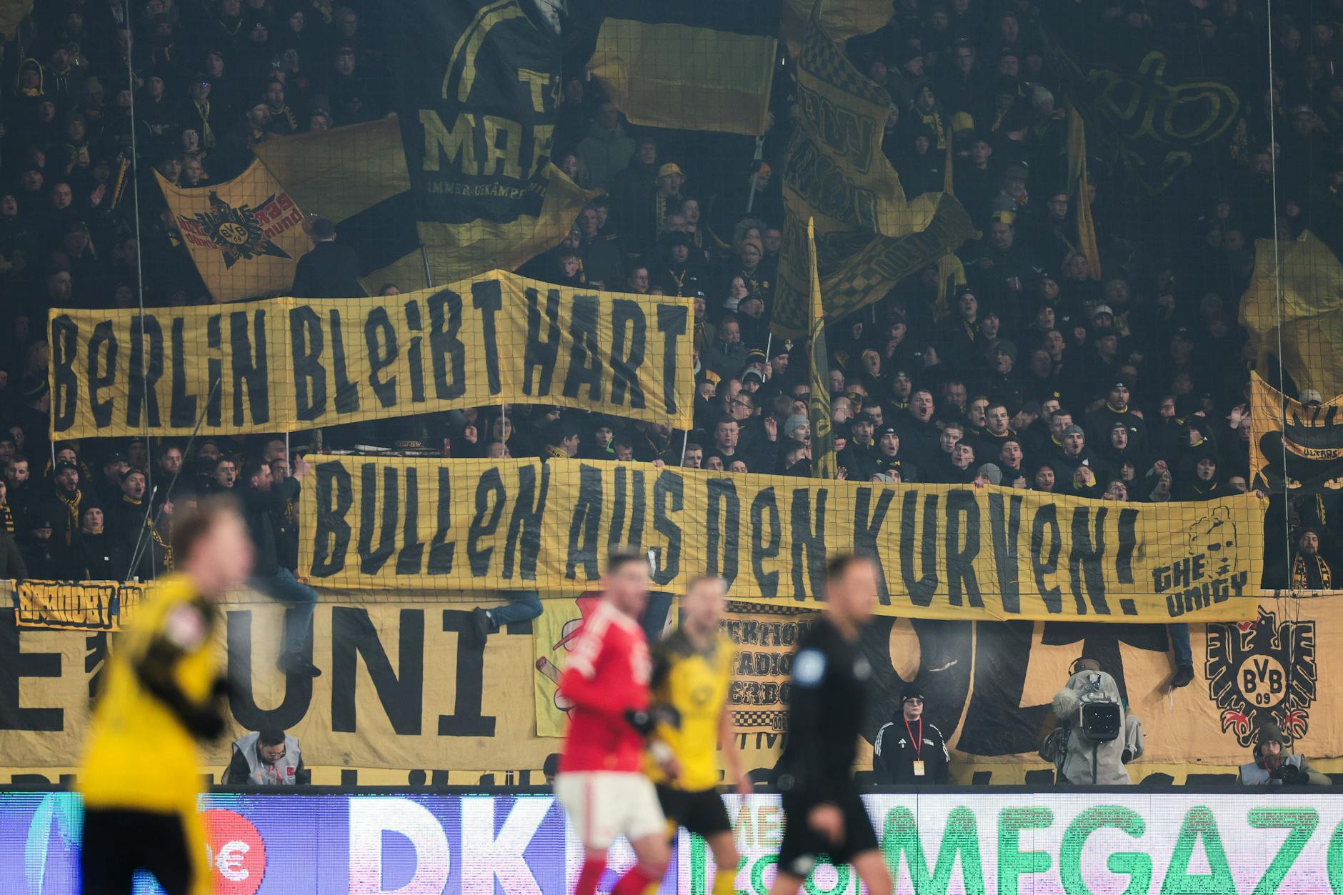 BVB-Fans solidarisieren sich während des Spiel beim 1. FC Union Berlin mit Spruchbändern mit den Anhängern von Hertha BSC