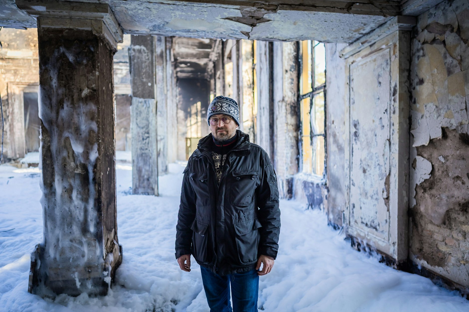 Nach dem Feuer: Oliver Borchert, Bürgermeister von Wandlitz, steht in dem ausgebrannten und mit Löschschaum bedeckten großen Saal des Lektionsgebäudes auf dem Bogensee-Areal. 