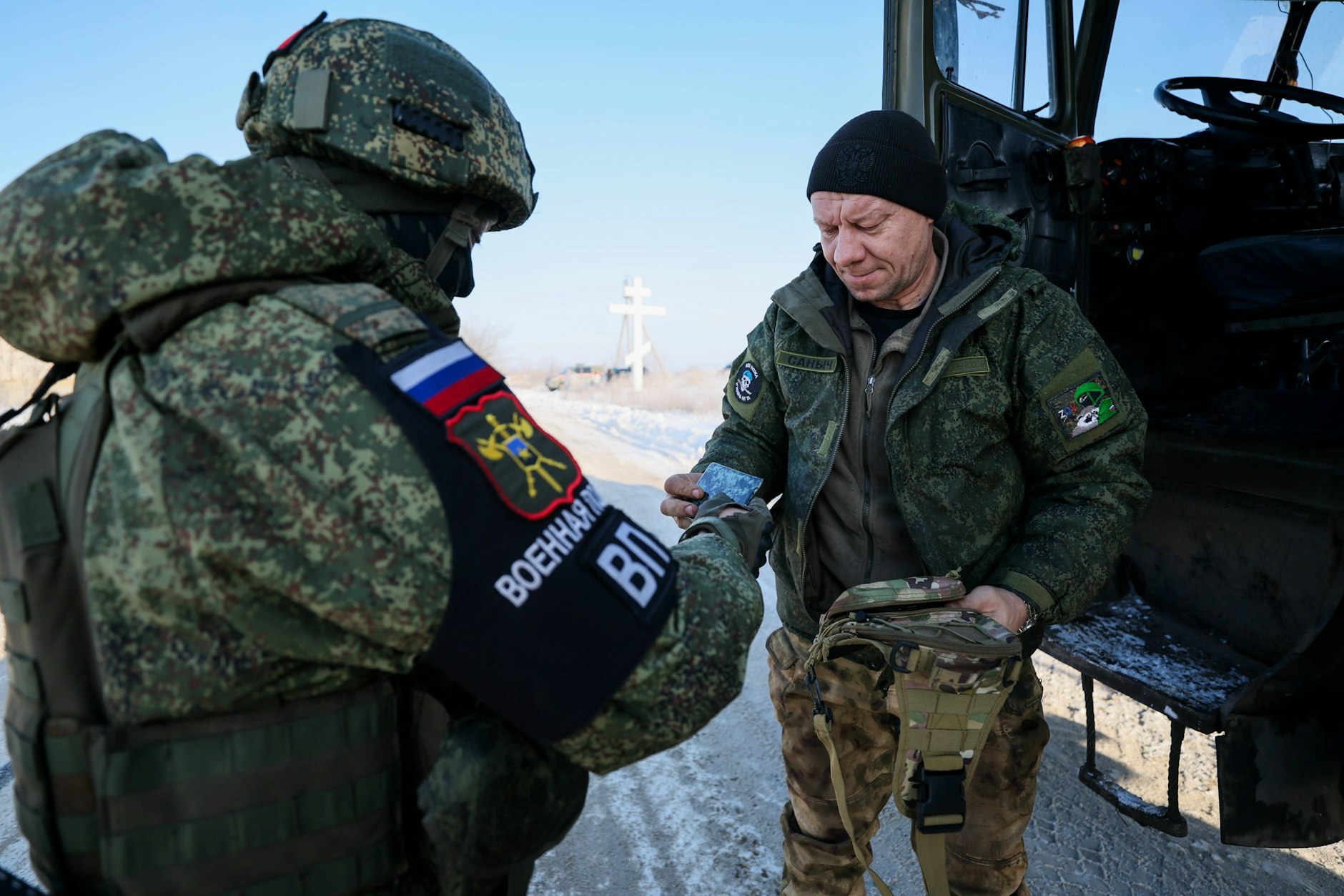 Ein Militärpolizist prüft Dokumente eines Lkw-Fahrers.