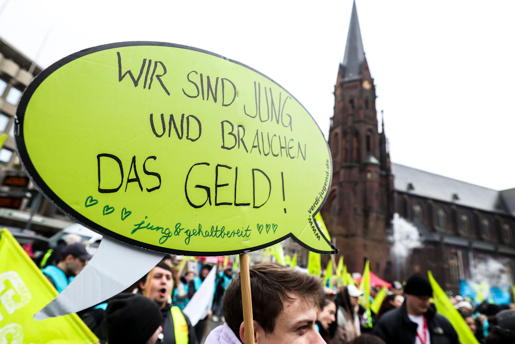 Bei einer Kundgebung demonstrieren Studenten: „Wir sind jung und brauchen das Geld!“