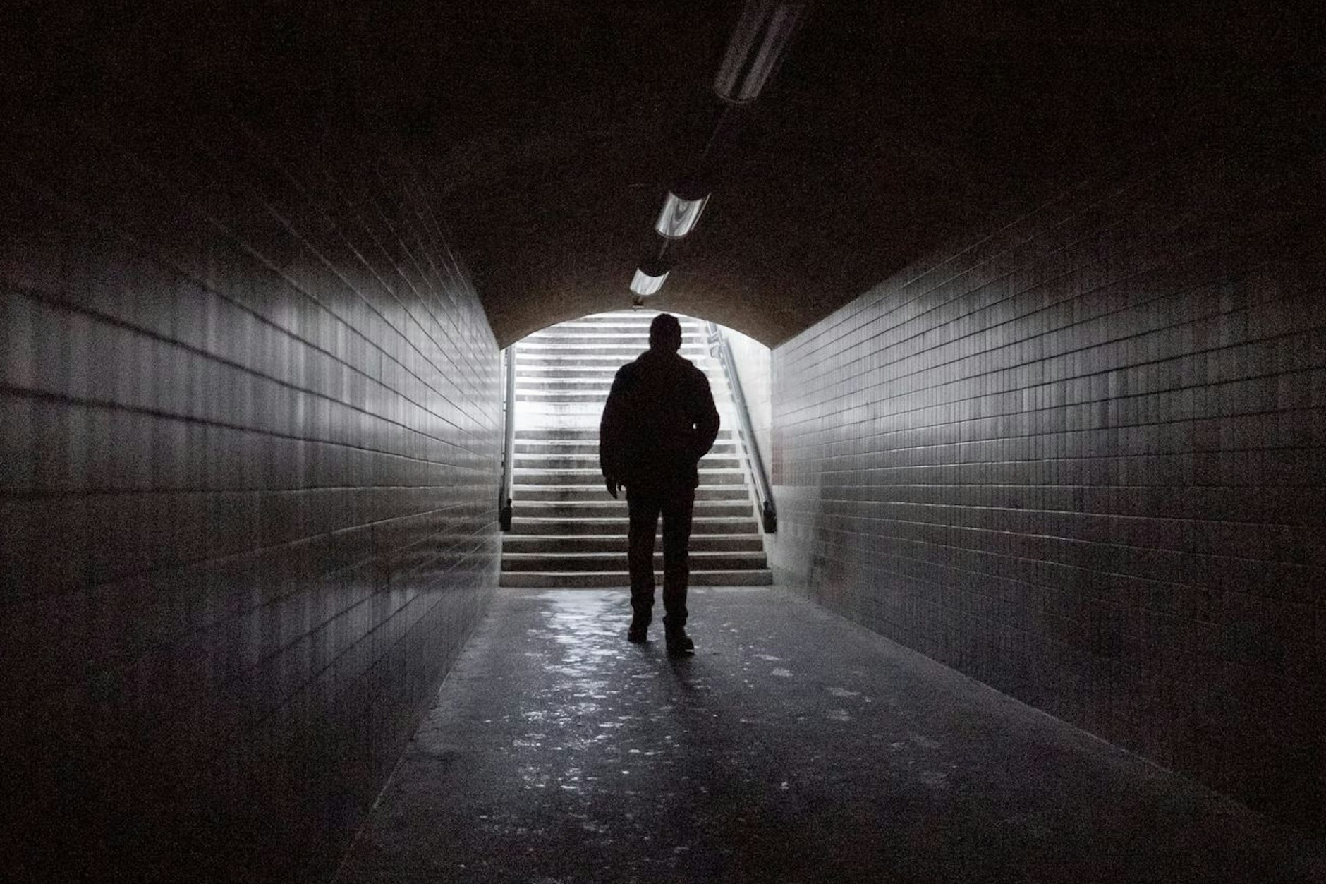 Eine Frau geht durch den Tunnel am Bahnhof Wannsee nach einem Stromausfall.