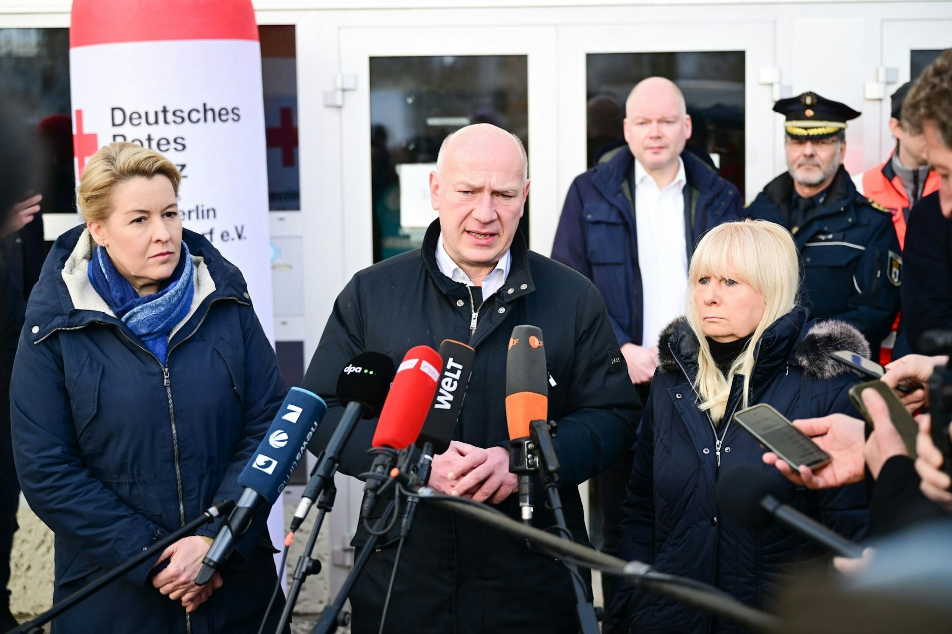 Kai Wegner (M.) spricht während des Stromausfalls vor einer Notunterkunft. Links: Wirtschaftssenatorin Franziska Giffey. Rechts: Innensenatorin Iris Spranger.