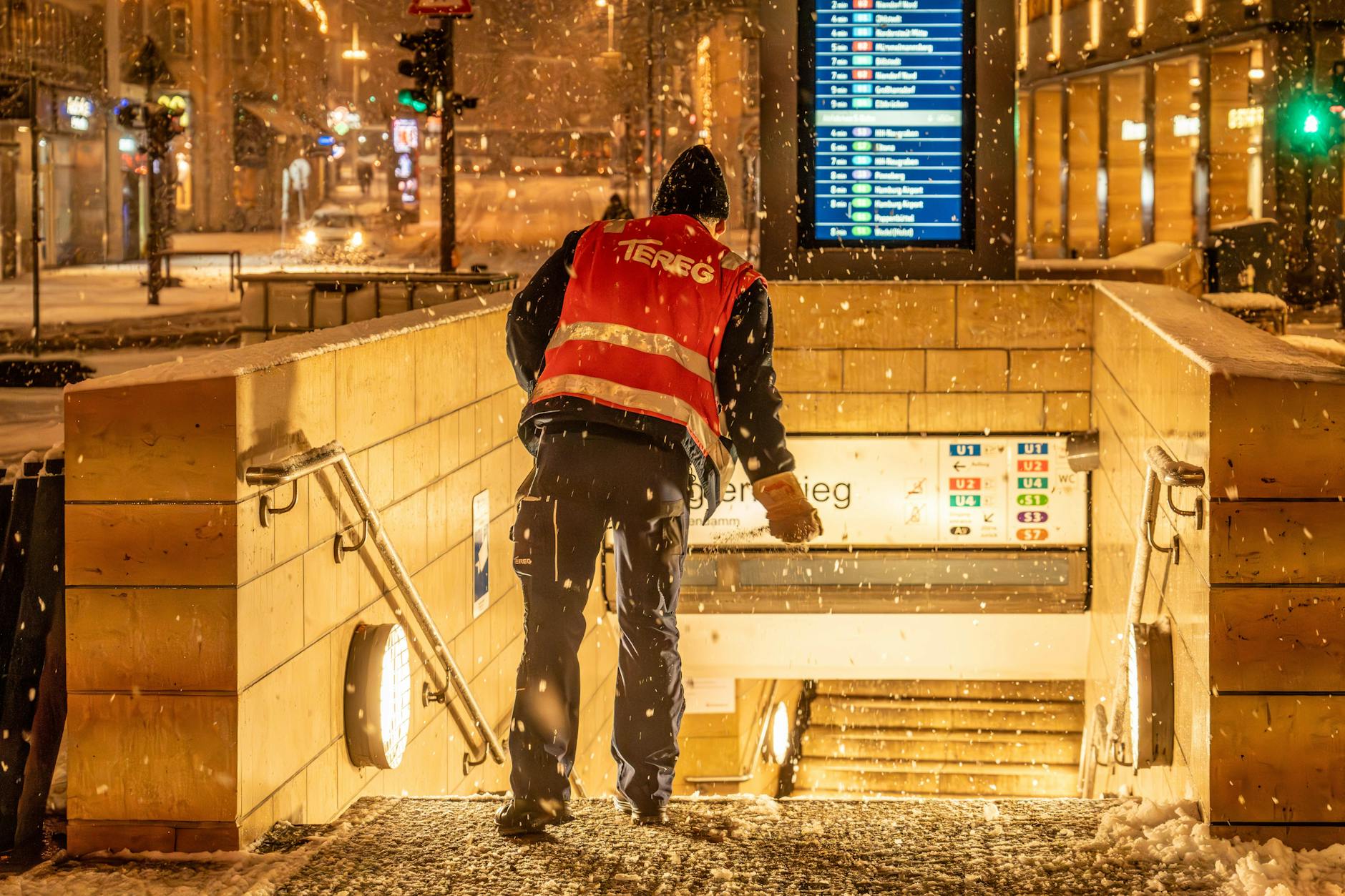 Ein Mitarbeiter streut an einem U-Bahn-Eingang. Zuständig ist das jeweilige Verkehrsunternehmen.