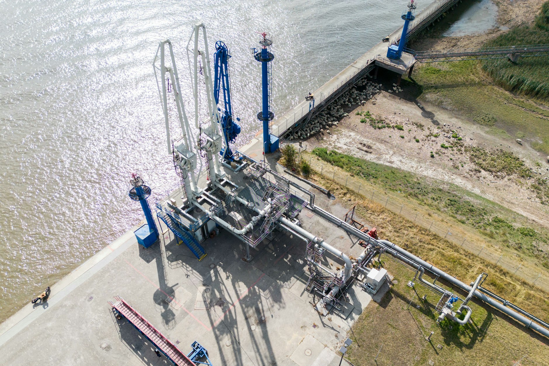 Löscharme und eine Pipeline sind an einem Terminal zum Entladen von Gas im Elbehafen in Brunsbüttel zu sehen. 2026 sollen hier die ersten LNG-Lieferungen aus Katar ankommen.