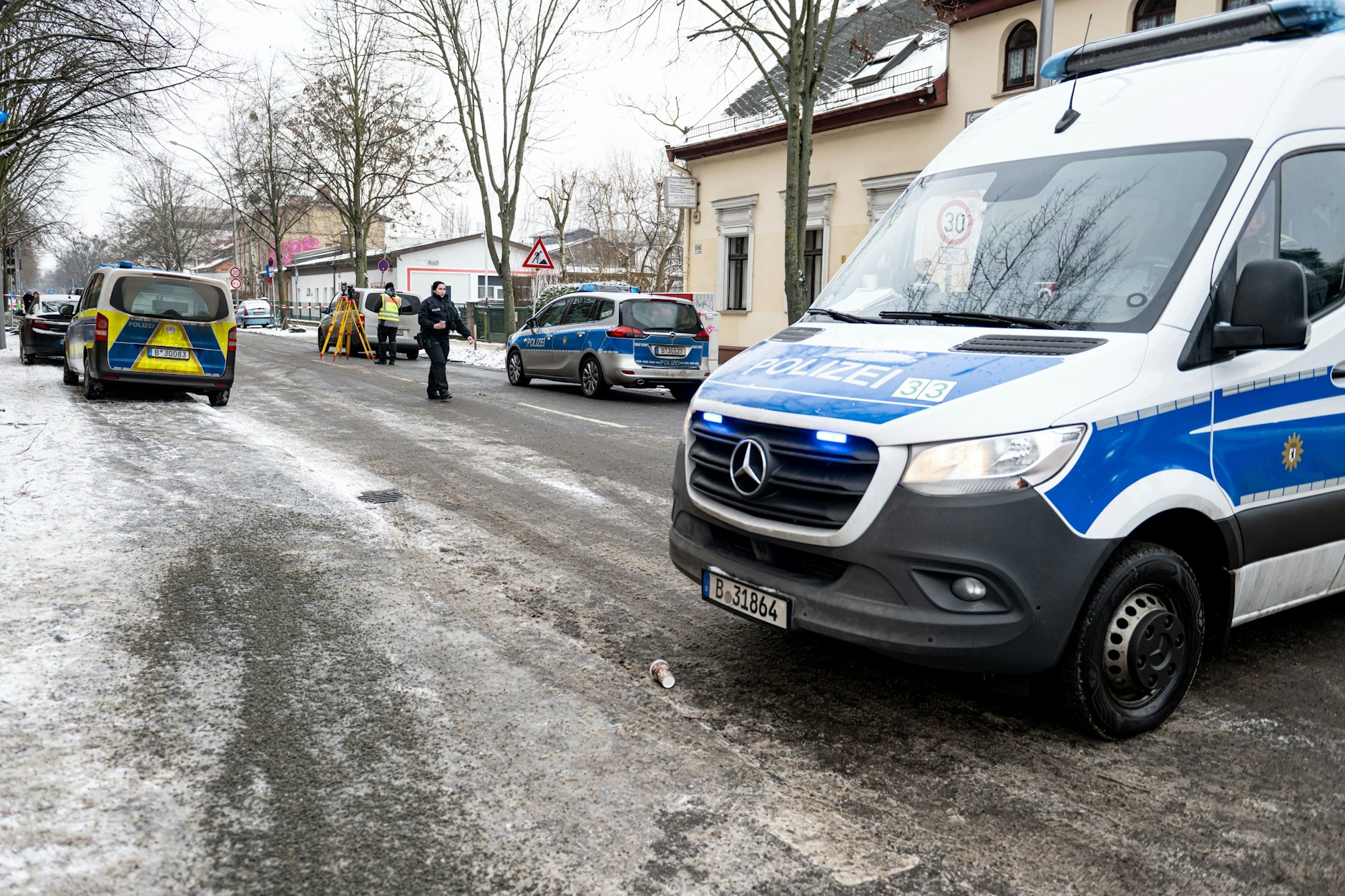 Die Polizei hat die Gustav-Adolf-Straße in Berlin-Weißensee abgesperrt: Hier wurde am Morgen ein 44-jähriger Mann in seinem weißen Mercedes-Transporter erschossen.