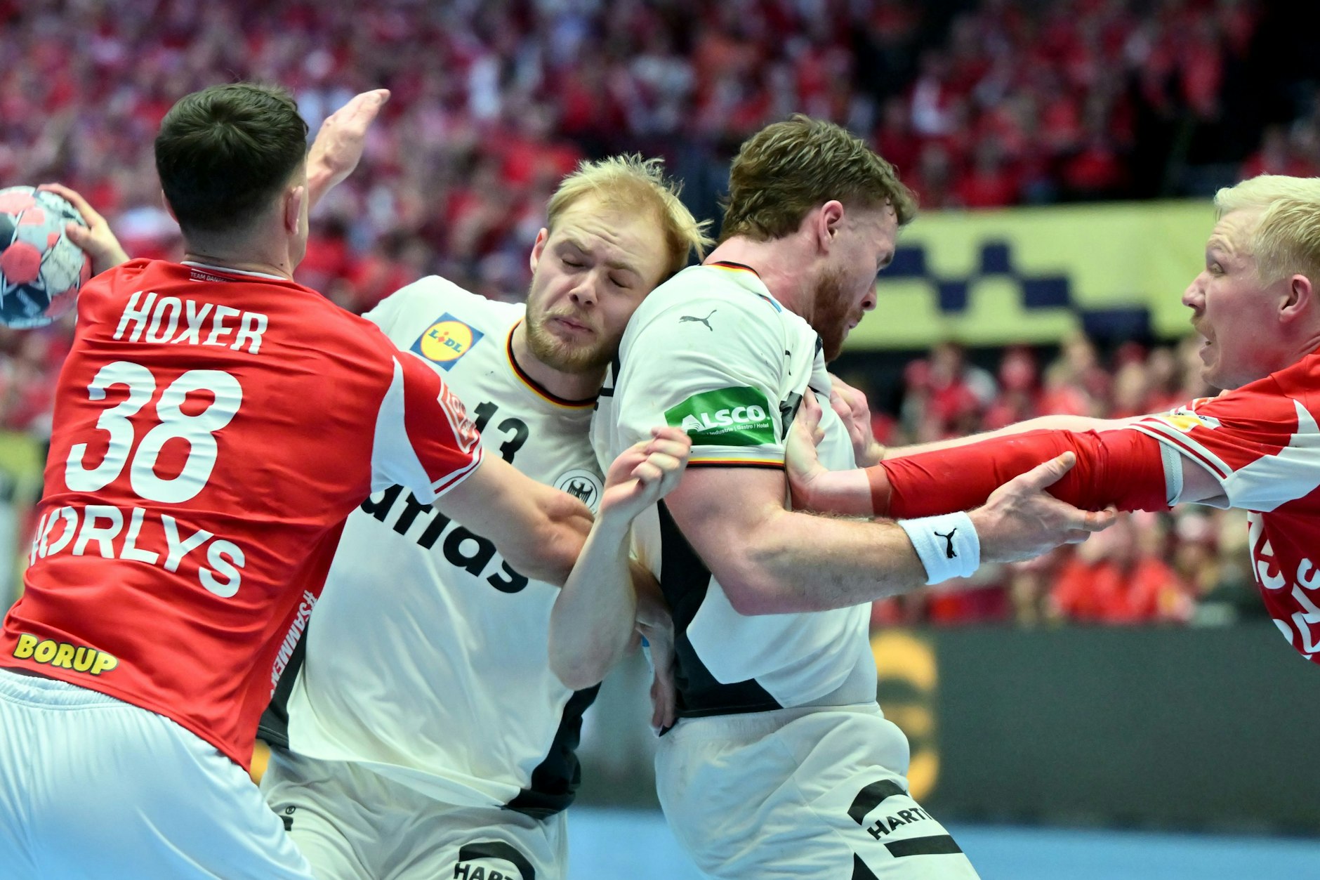 Matthes Langhoff (2.v.l.) von den Füchsen Berlin versucht sich, gegen die Dänen Mads Hoxer (l.) und Magnus Saugstrup (r.) durchzusetzen.