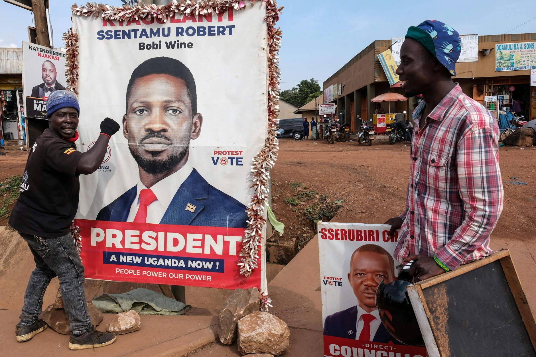 Ein Anhänger des oppositionellen ugandischen Präsidentschaftskandidaten Robert Kyagulanyi, bekannt als Bobi Wine, hält ein Wahlkampfplakat fest.