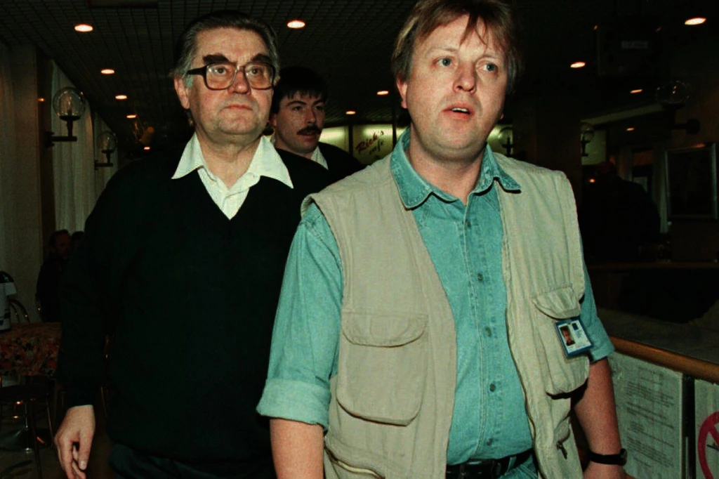 Der EU-Administrator für Mostar,&nbsp;Hans Koschnick (l.), wird von Sicherheitspersonal begleitet, als er am Morgen des 8. Februar die Lobby des Hotels Ero passiert, nachdem er sich weigerte, eine Erklärung gegenüber Journalisten abzugeben.